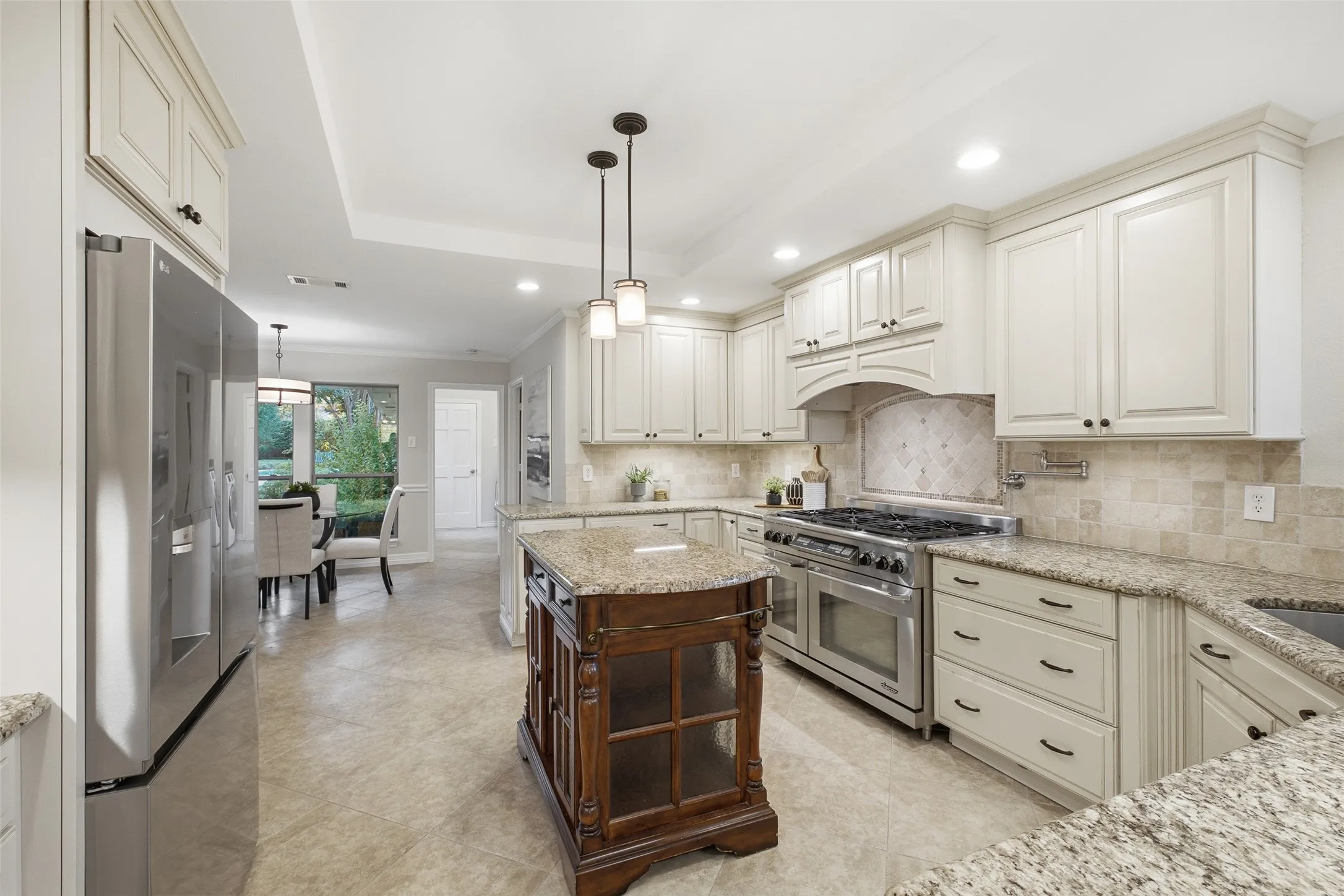 Smart kitchen storage: raised-panel cabinetry with toe-kick drawers, pendant lighting and a tray ceiling.
