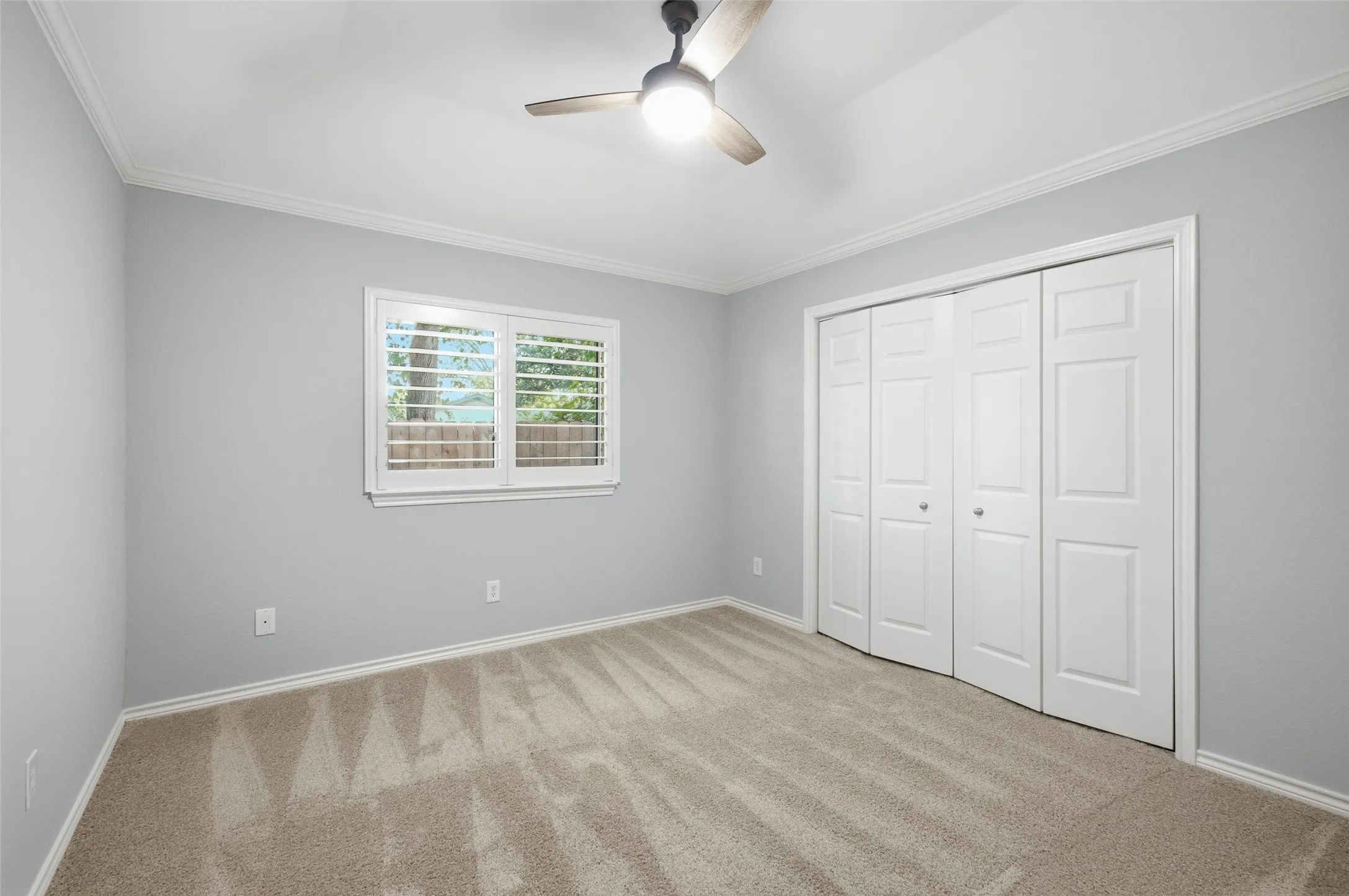 Calm blue walls, ceiling fan and a generous closet make this bedroom a restful retreat.