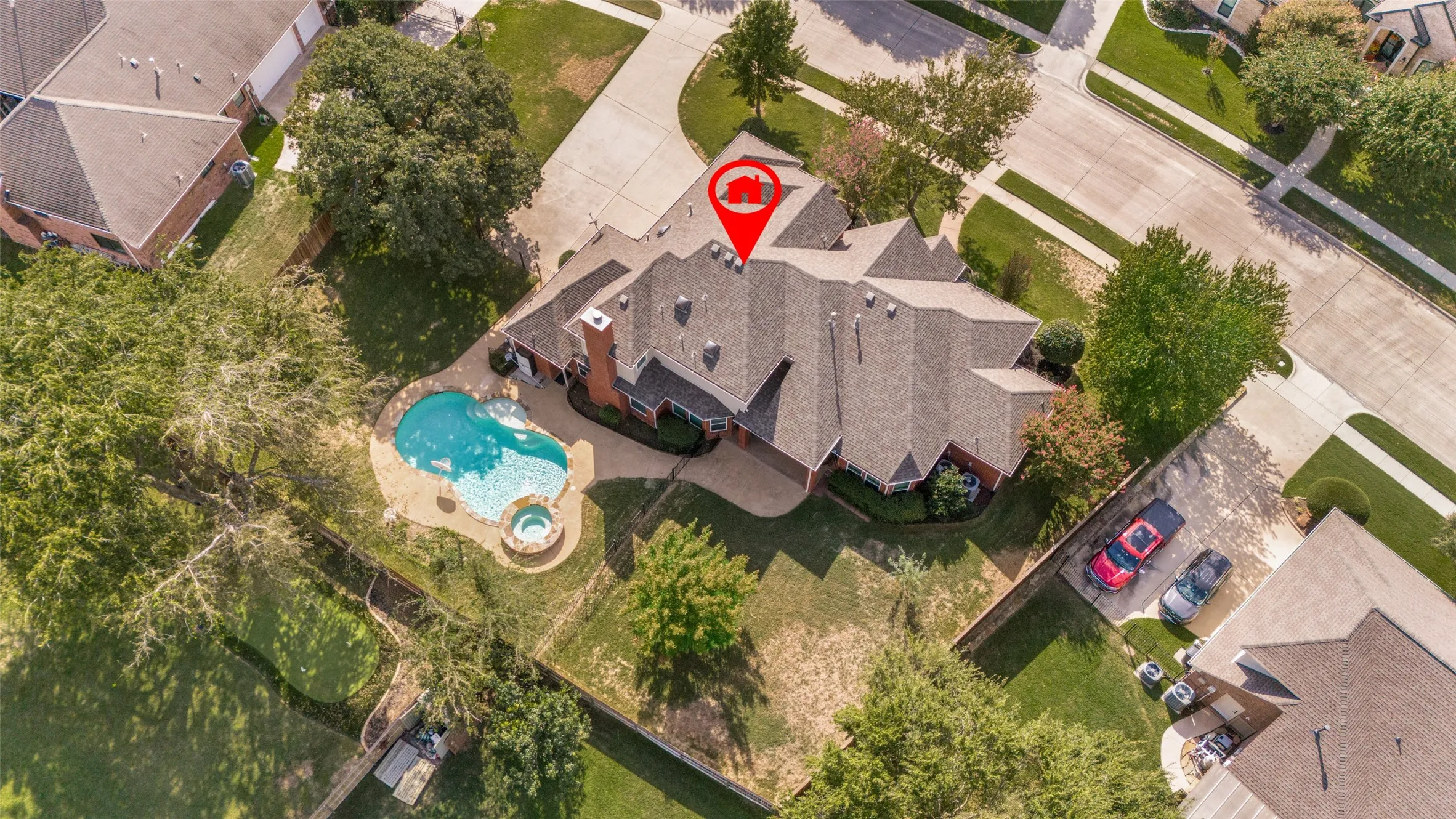 Aerial perspective of a multi-gabled residence featuring a swimming pool, integrated spa, and expansive lawn