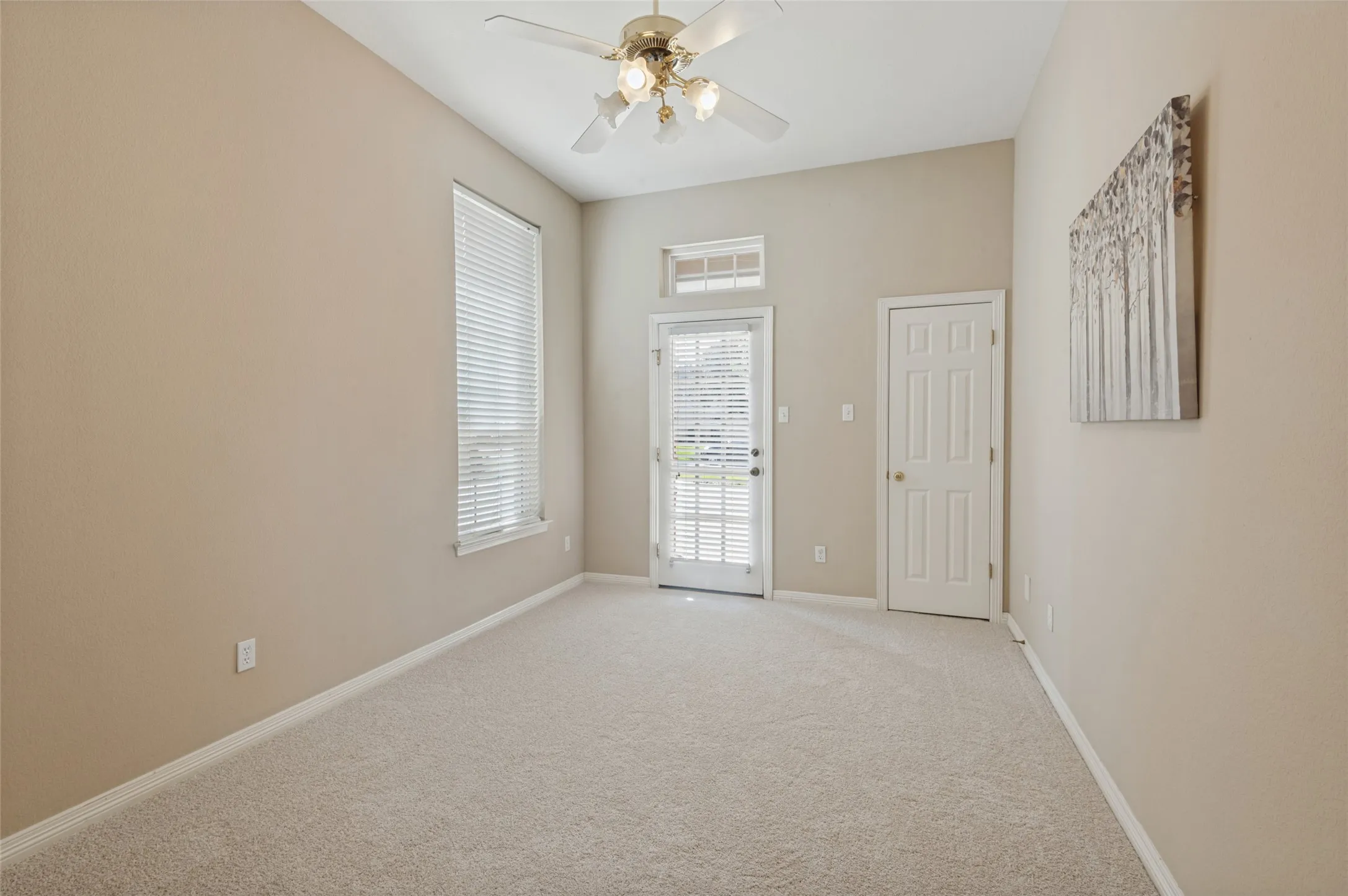 Split bedroom on the first floor with ceiling fan and walk-in closet