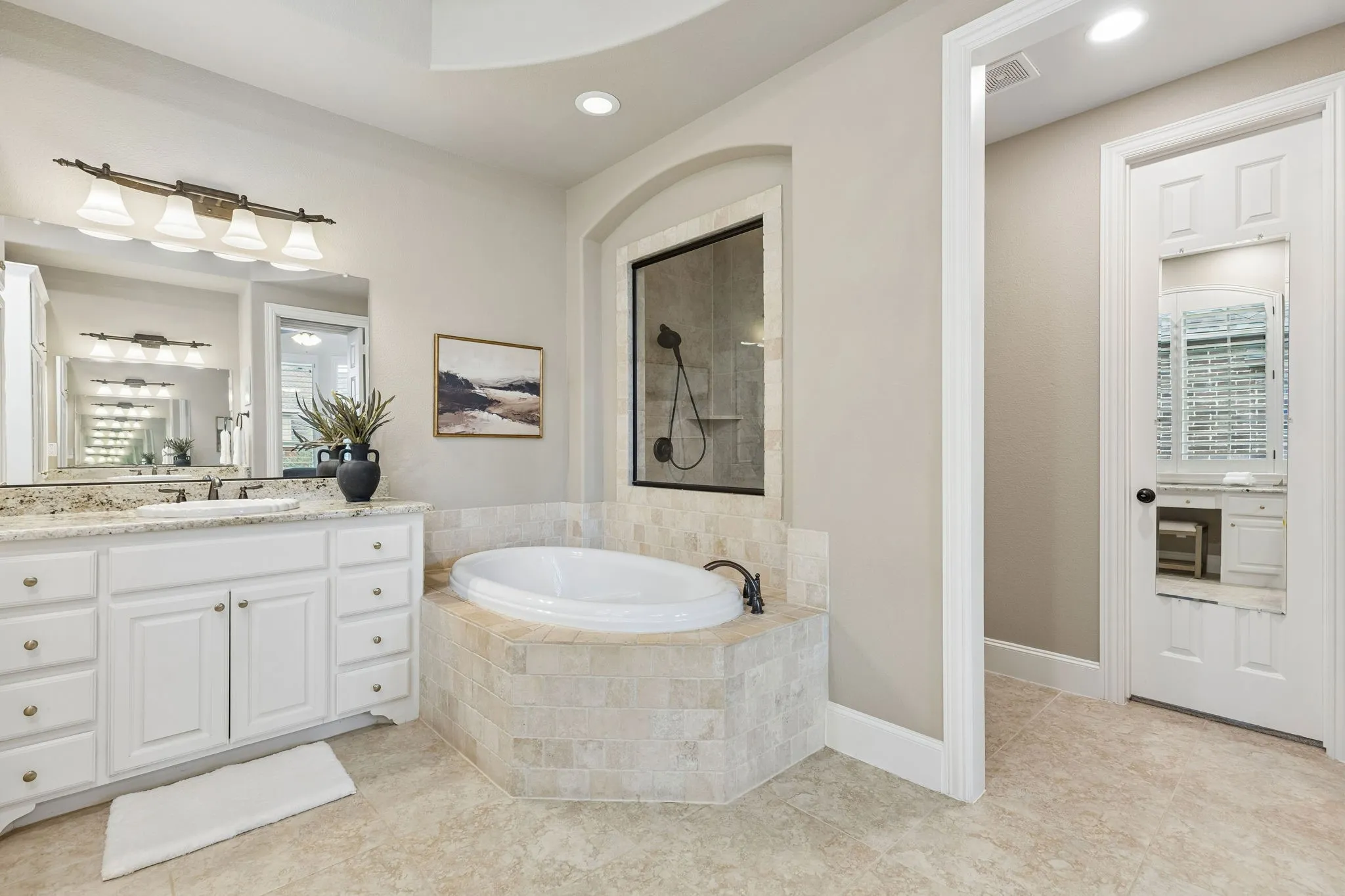 Bathroom featuring white cabinetry, a stone-tile surround soaking tub, recessed lighting, and a neutral tile floor