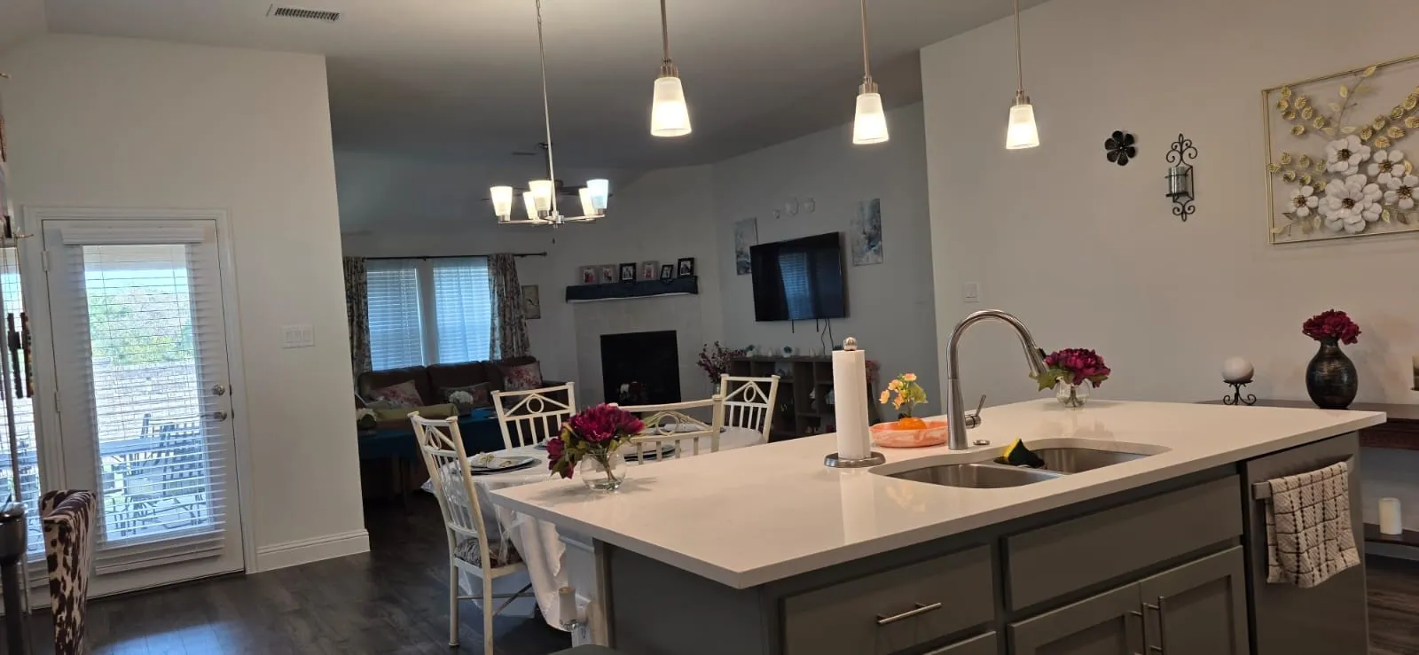 Kitchen island with a double basin sink, gooseneck faucet, and pendant lighting
