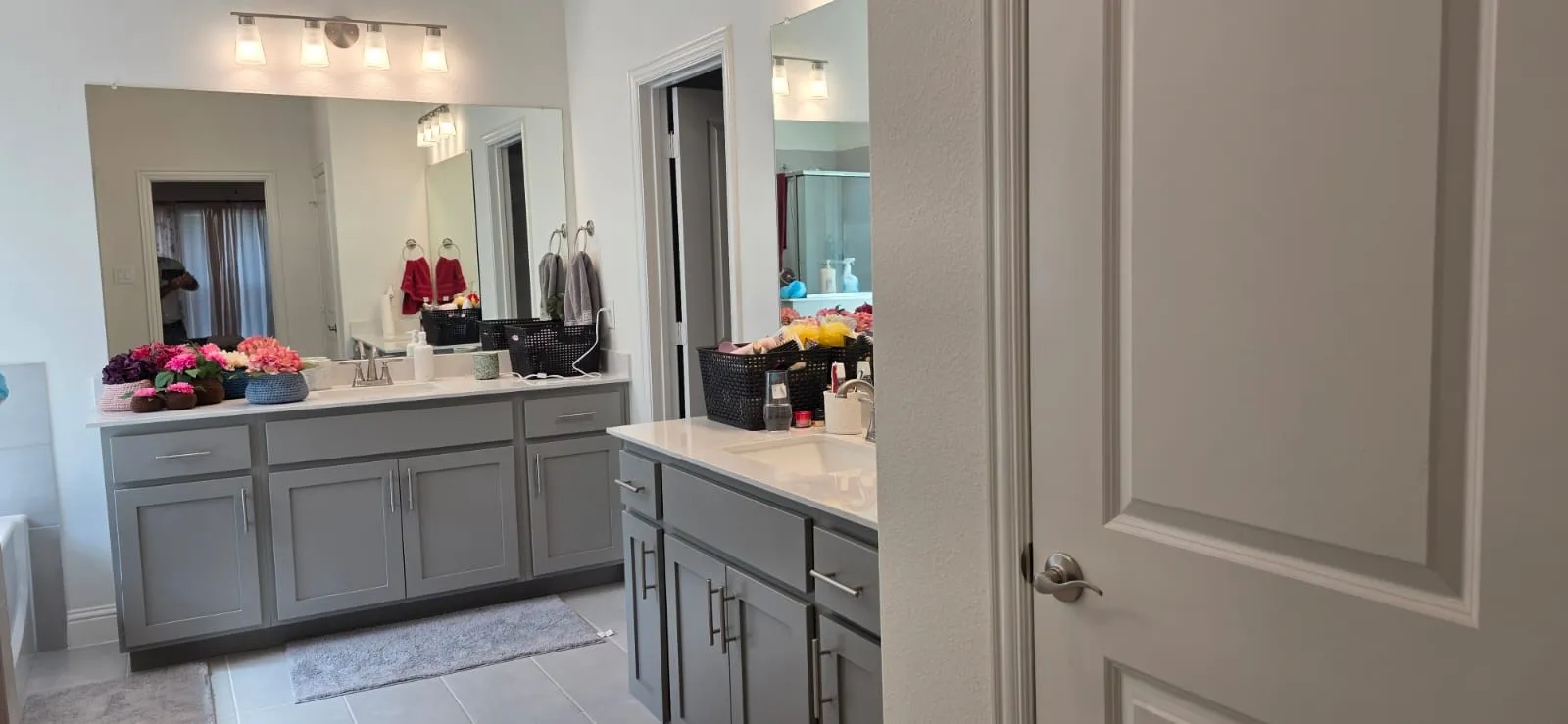 Dual vanities with white countertops, integrated sinks, and gray cabinetry