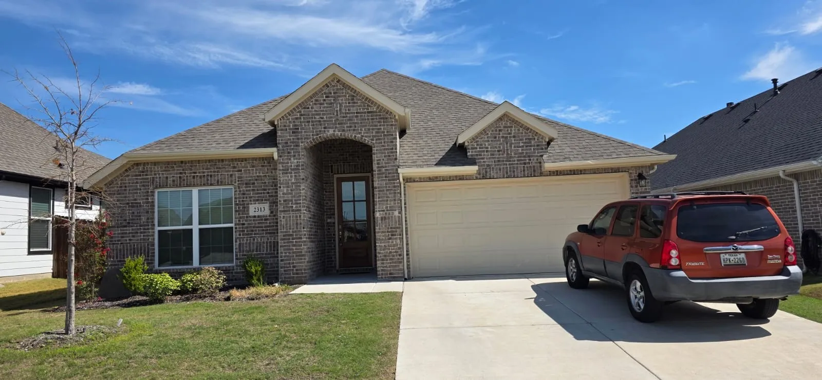 Brick exterior with stone accents, covered entry, and an attached two-car garage
