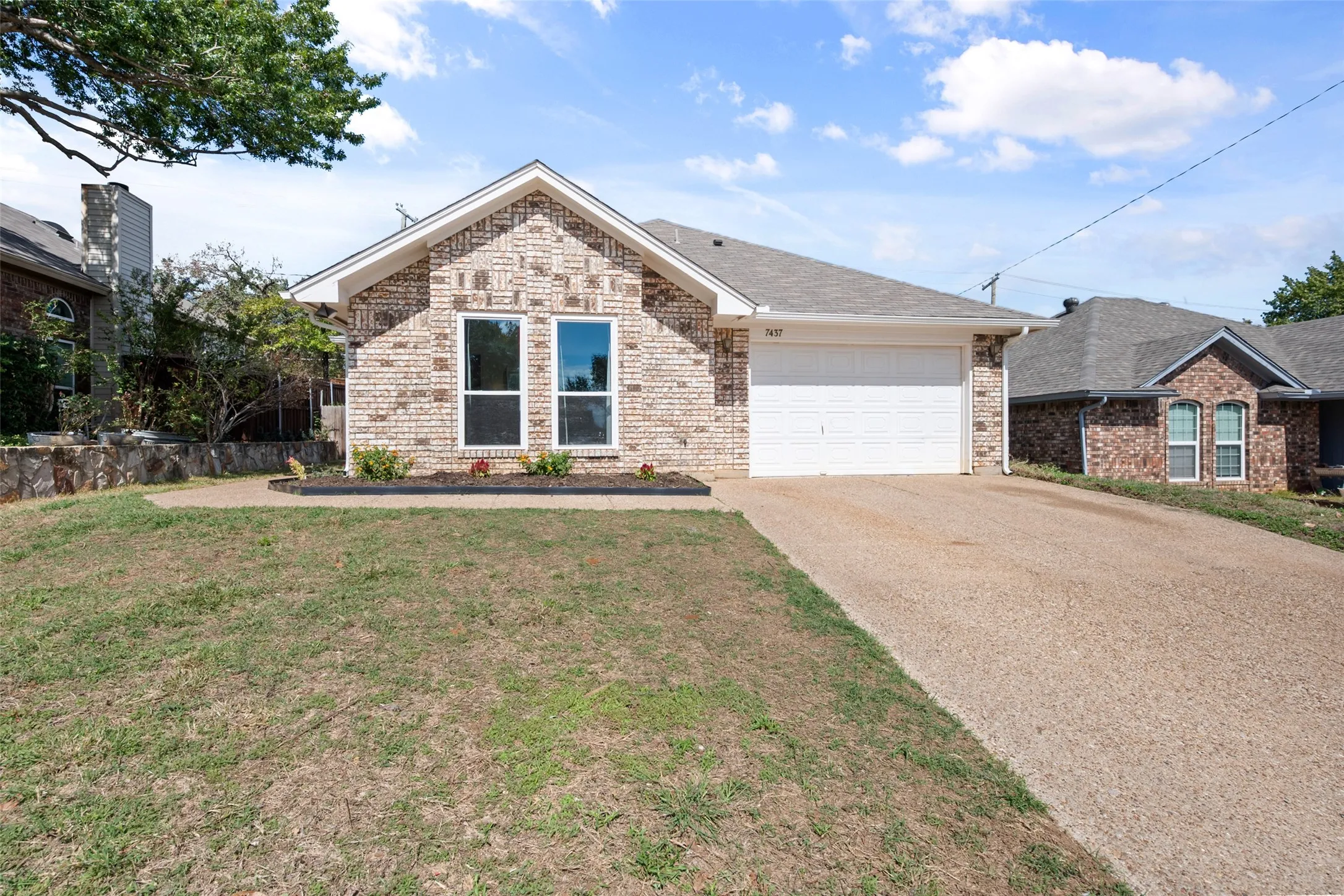 Single-story brick exterior featuring a gable roof, attached two-car garage, and concrete​​‌​​​​‌​​‌‌​‌‌​​​‌‌​‌​‌​‌​​​‌​​ driveway