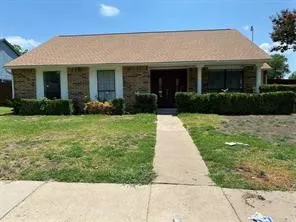 Single-story brick exterior featuring a shingled roof, double-door entrance, and decorative columns