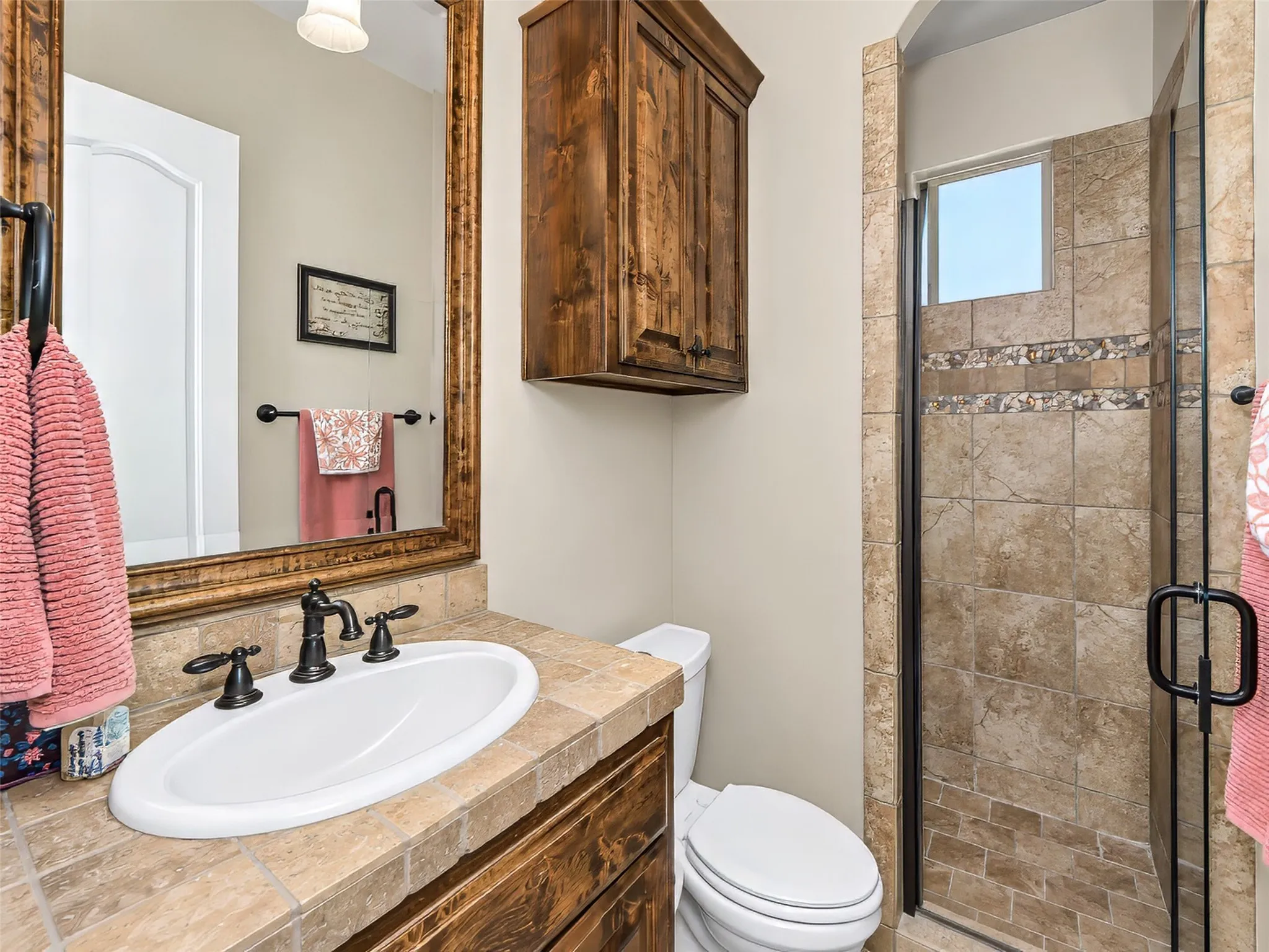 This guest bathroom downstairs features a custom shower and built in vanity.