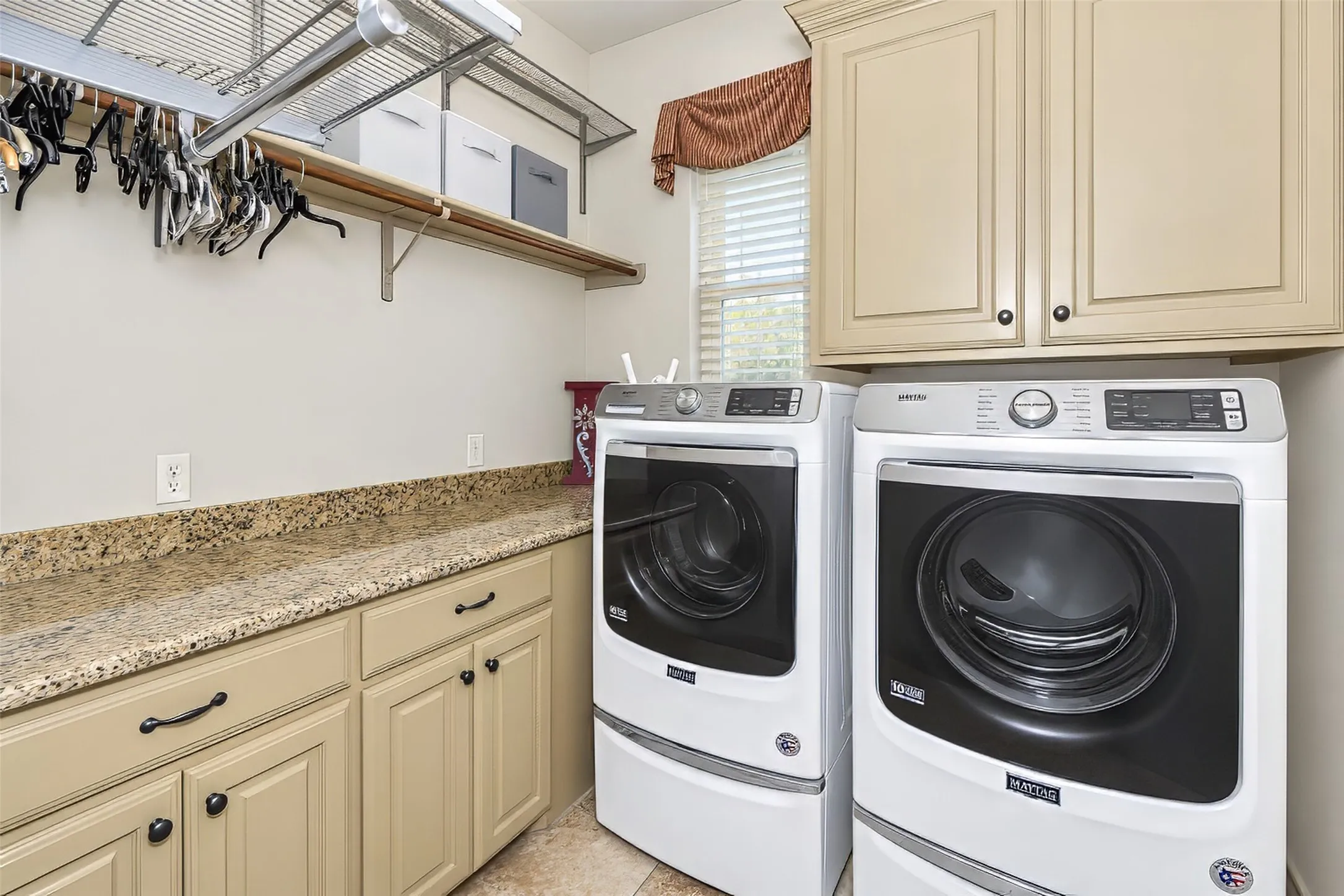 Large laundry room is large enough for jumbo sized washer and dryer, and features built in cabinetry.