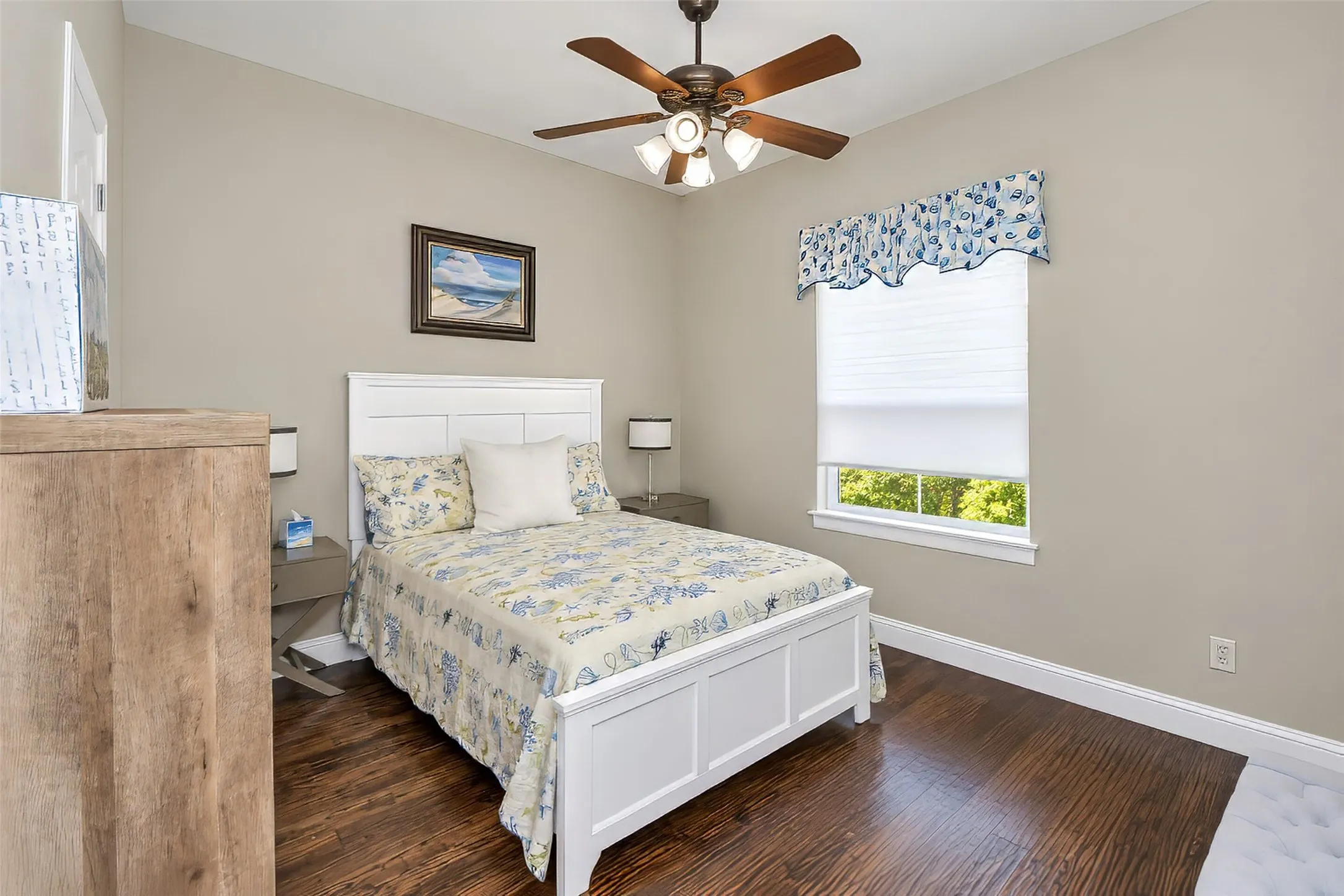 The downstairs guest bedroom features wood flooring and a window to the back yard.