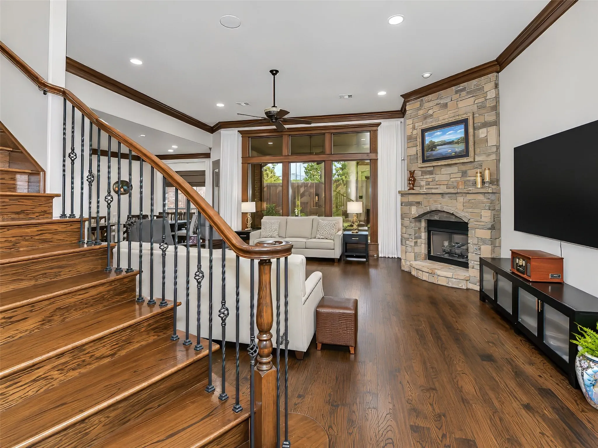 Staircase features wood treads, handrail and newel posts with iron ballusters.