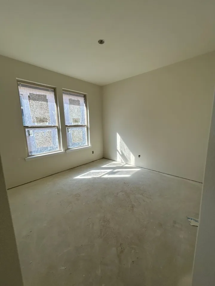 Two windows providing natural illumination, recessed ceiling lighting, and neutral wall tones