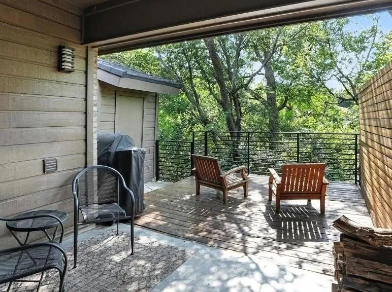 Covered deck featuring wood-finish decking, horizontal slat privacy fencing, and black metal railing