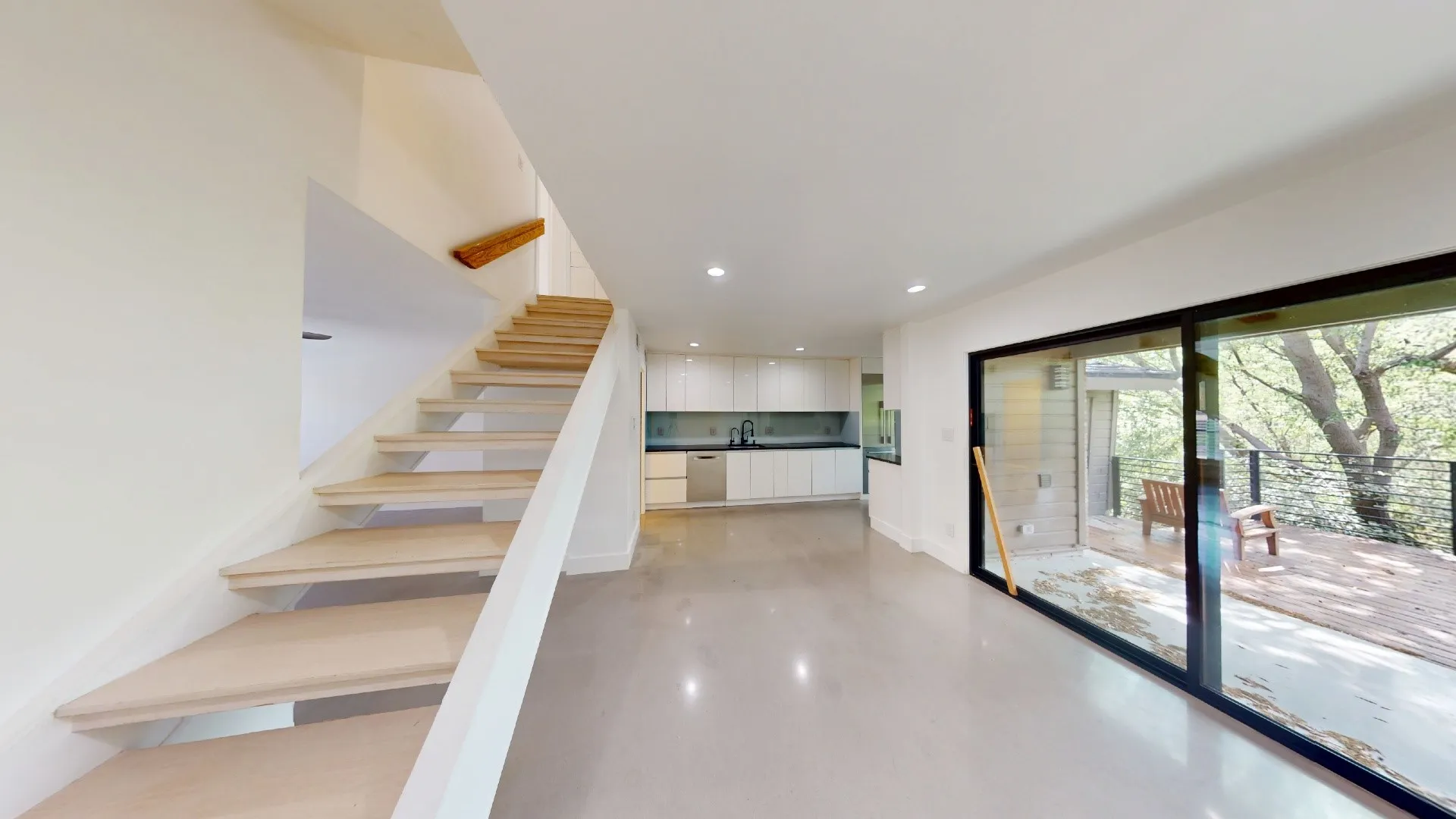 Open floor plan featuring a staircase with wood treads, flat-panel cabinetry, recessed lighting, and large sliding glass doors