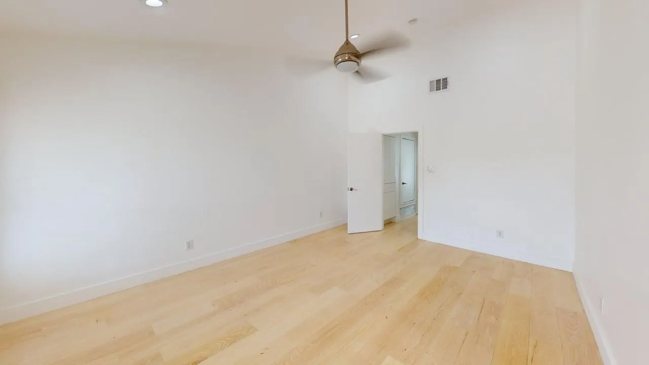 Vaulted ceilings, wood-finish flooring, recessed lighting, and a neutral-tone ceiling fan