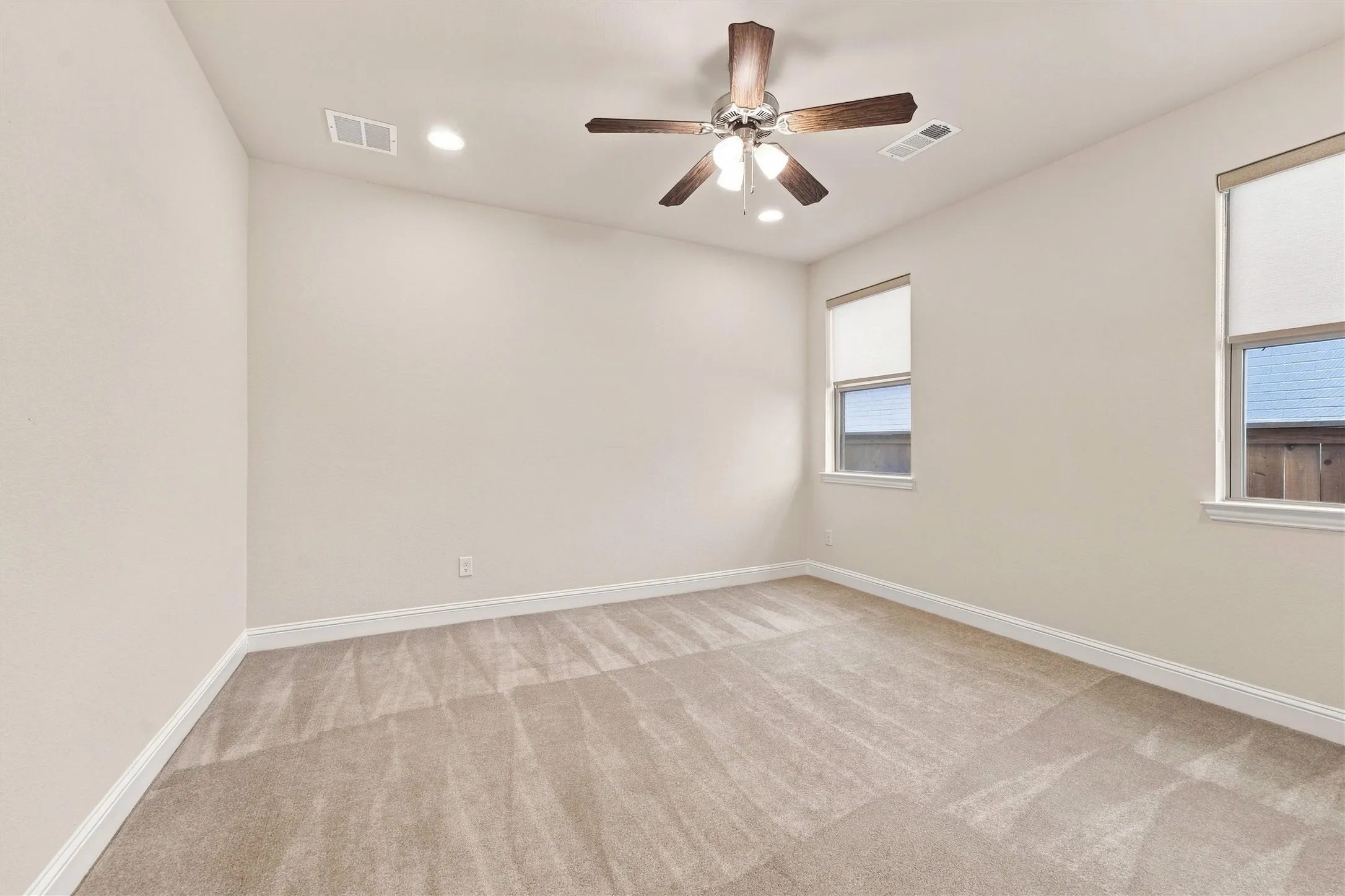 Neutral-toned interior featuring wall-to-wall carpeting, recessed lighting, and a multi-blade ceiling fan with integrated lighting