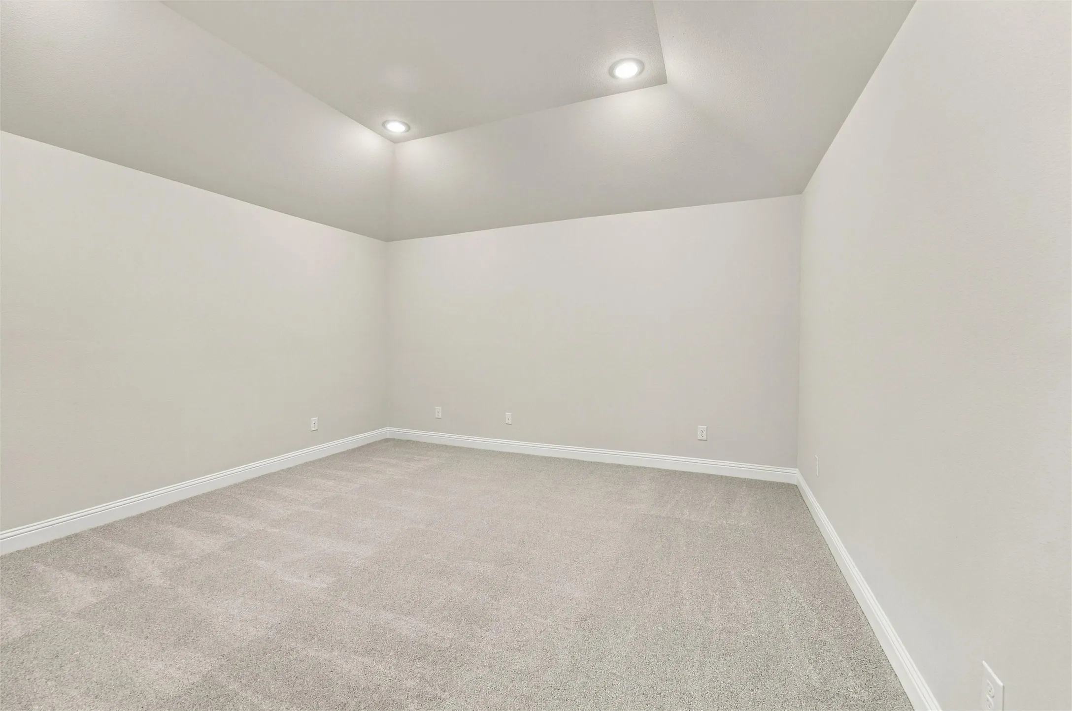 Vaulted ceiling featuring recessed lighting and neutral wall-to-wall carpeting