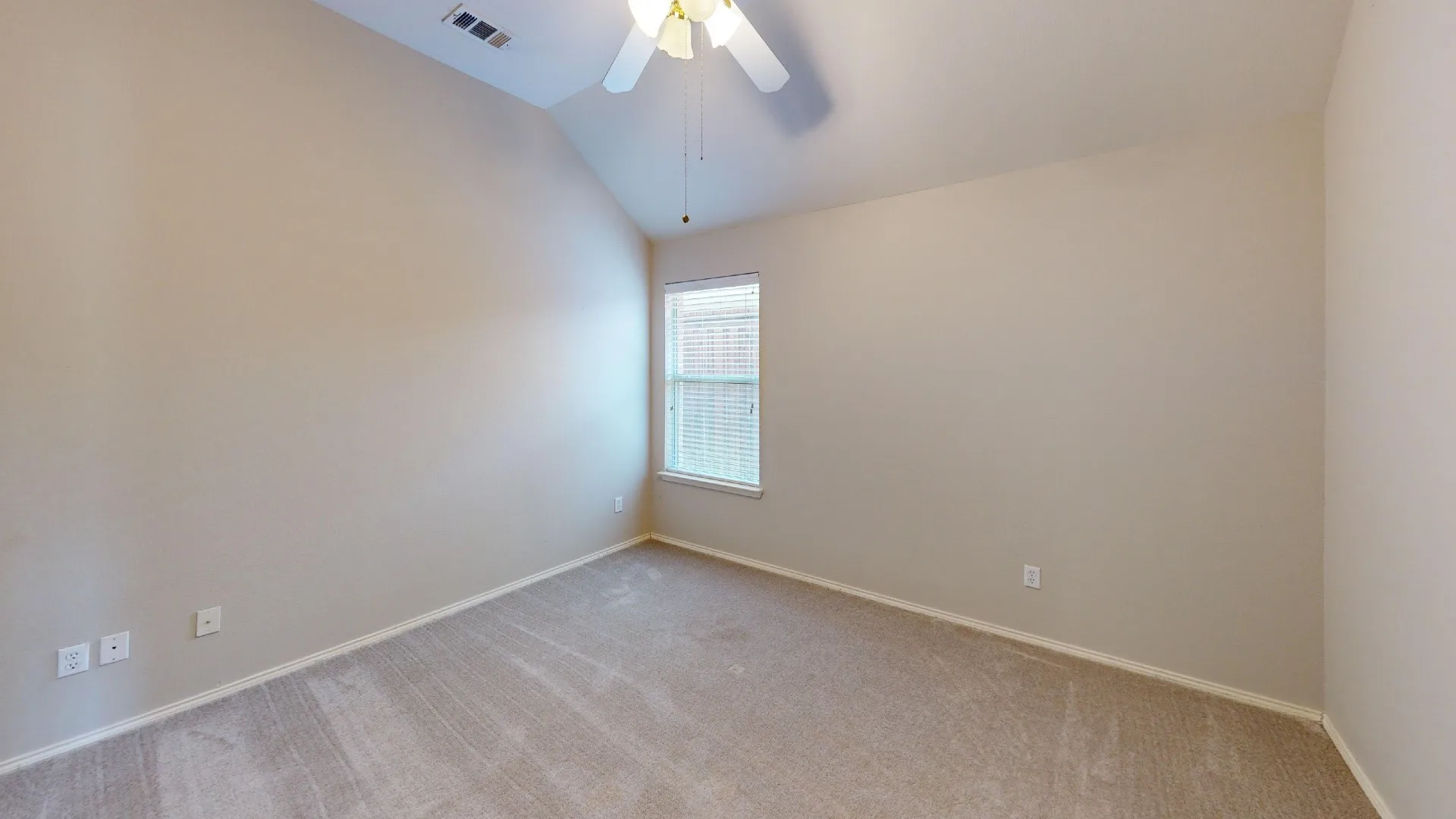 Vaulted ceiling featuring a ceiling fan with light kit, neutral carpeting, and a window with blinds
