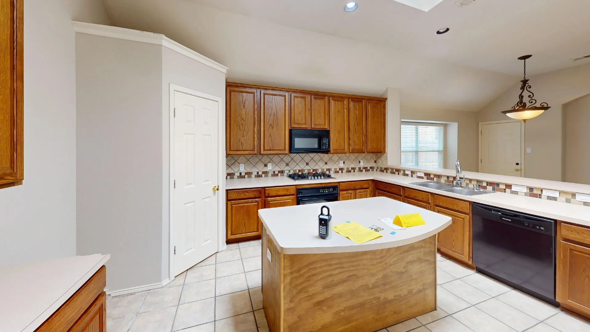 Kitchen featuring stained wood cabinetry, central island, tile backsplash, built-in cooktop, and tile flooring