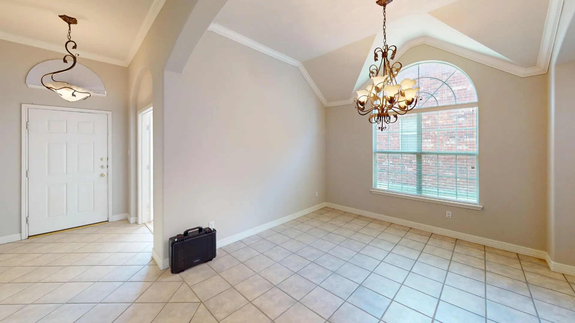 Entry featuring ceramic tile flooring, vaulted ceilings, ornate multi-light chandeliers, and an arched window