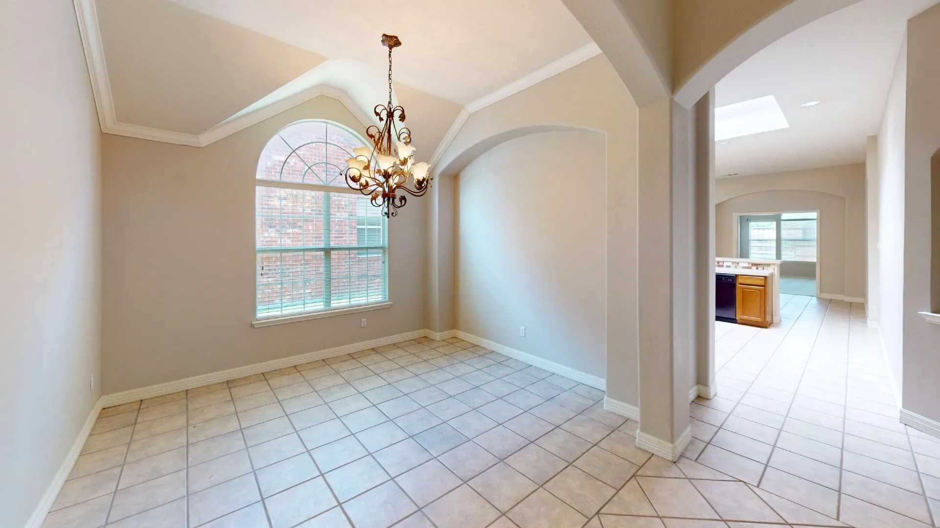 Vaulted ceiling, arched window, decorative chandelier, arched architectural accents, and tile flooring