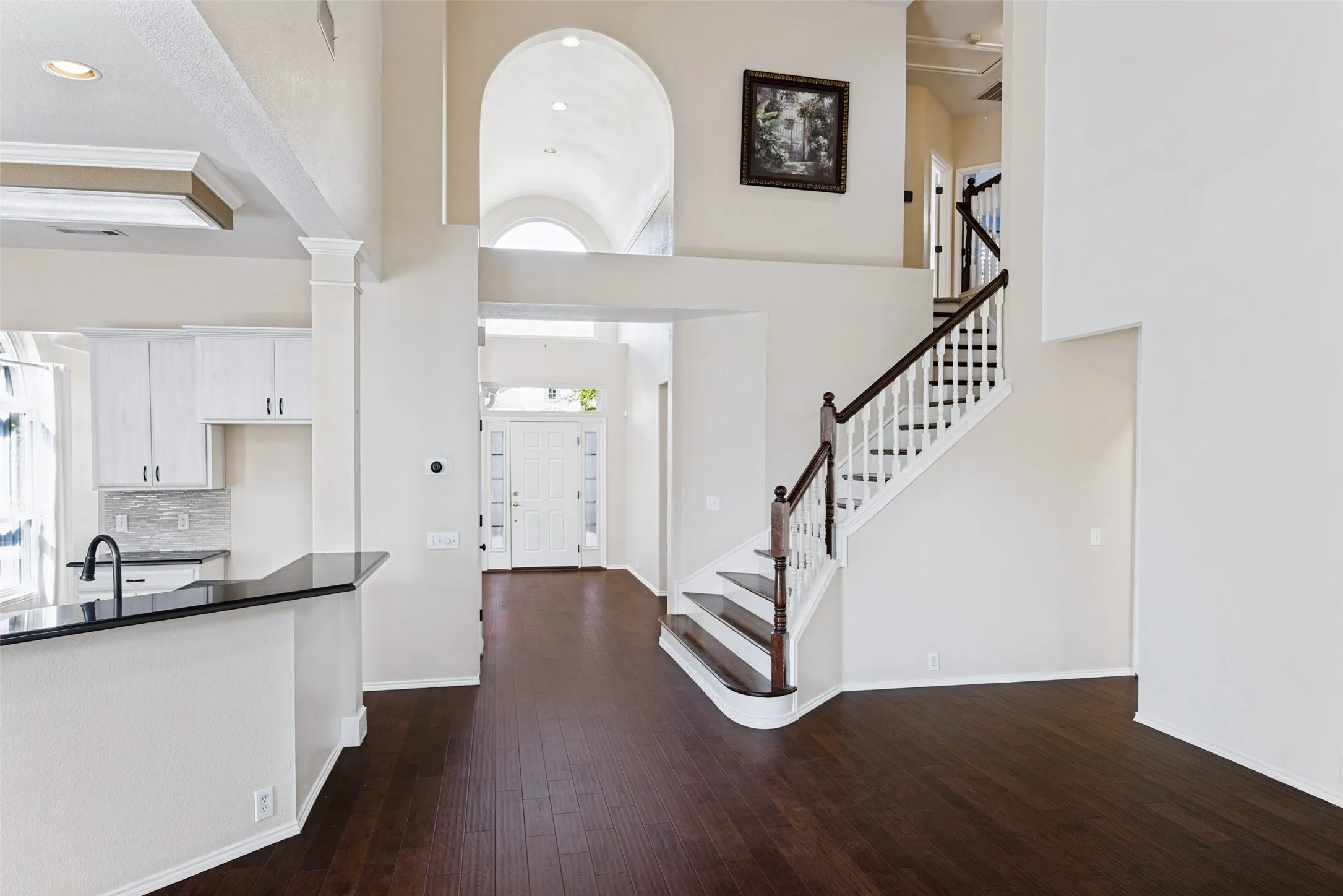 Front of home featuring high ceilings, engineered wood flooring