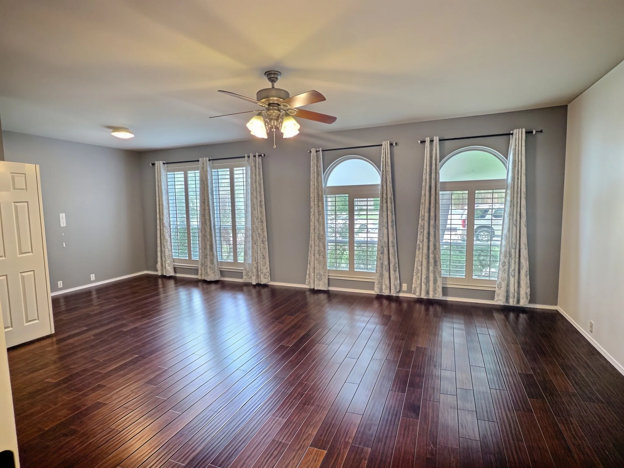 Primary bedroom with engineered wood flooring, plantation shutters, and flex space