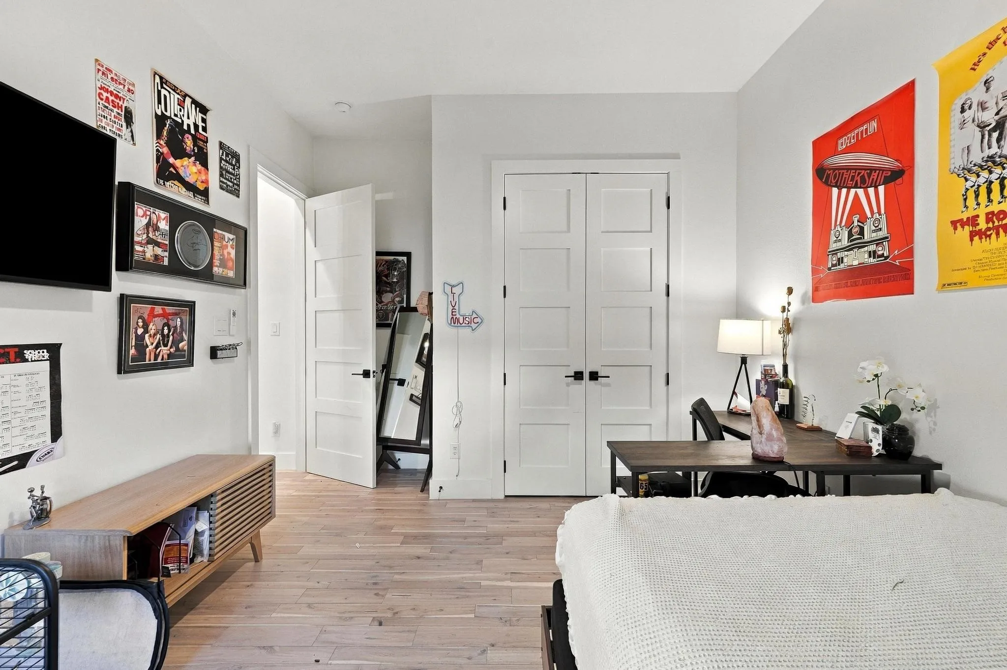 Wood-finish flooring, neutral wall tones, and five-panel interior doors with matte black hardware