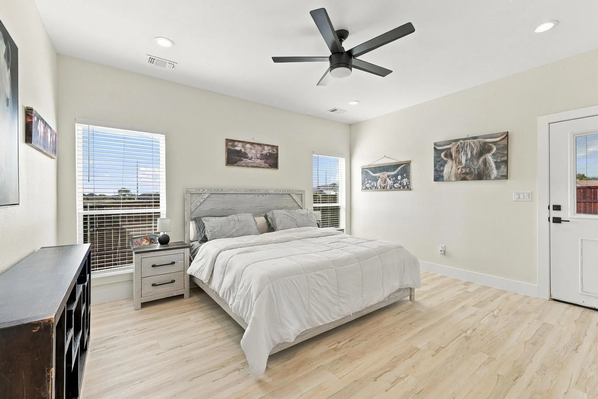 Neutral-toned room featuring wood-finish flooring, recessed lighting, a modern ceiling fan, and an exterior door with integrated window panel