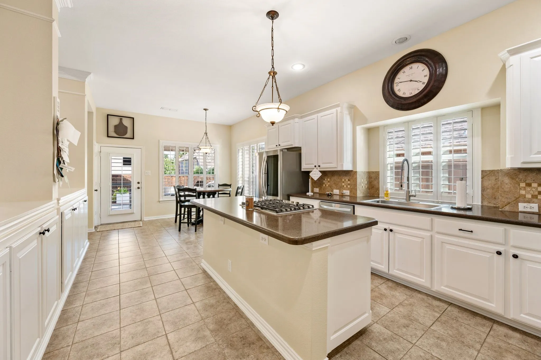Spacious and bright kitchen has recently updated stainless appliances and plantation shutters. It is open to the living room and has two pantries and an abundance of storage.