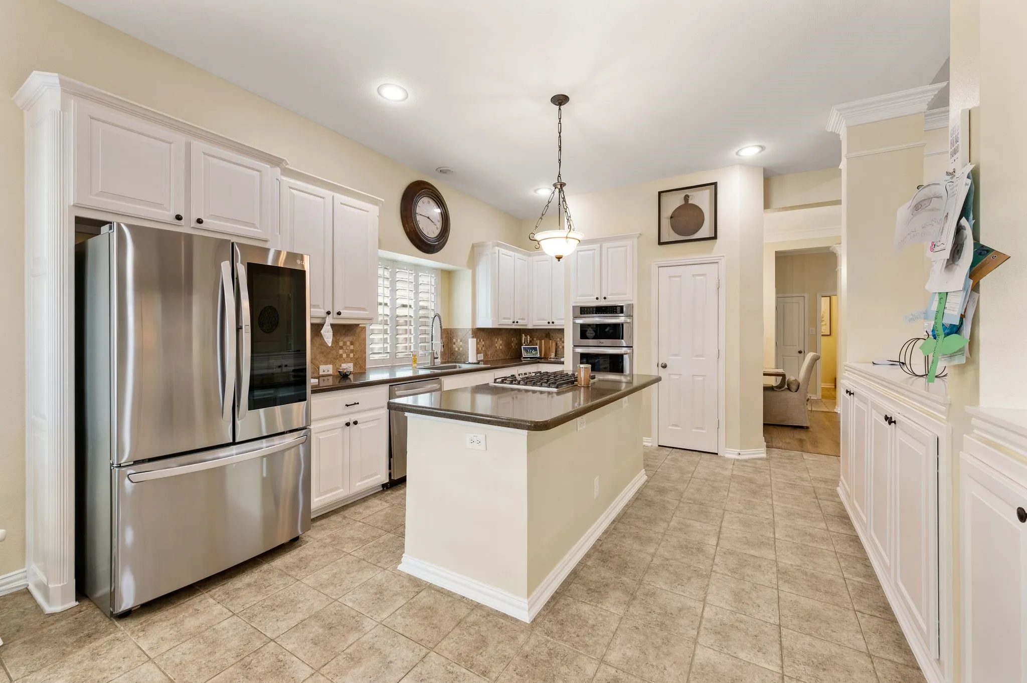 Pretty kitchen has fresh white cabinets and recently upgraded stainless appliances including gas cooktop.  There is so much storage with two pantries and the additional bank of cabinets between kitchen and living.