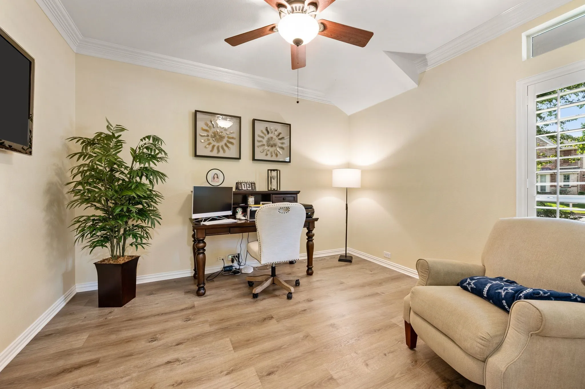 Dedicated office off front entry with wood tone floors, French doors and plantation shutters