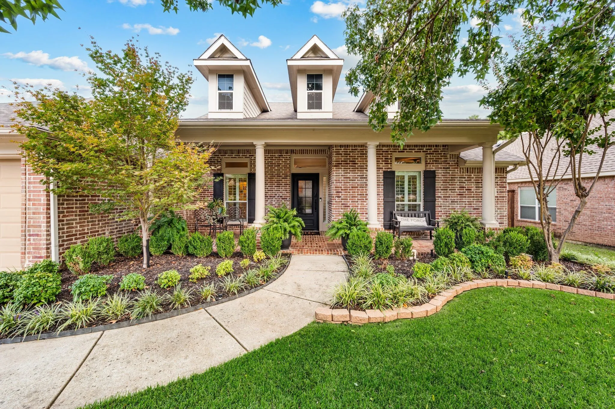 Manicured landscaping, classic architecture and a spacious brick covered front porch spell CURB APPEAL! isn't she lovely?!?