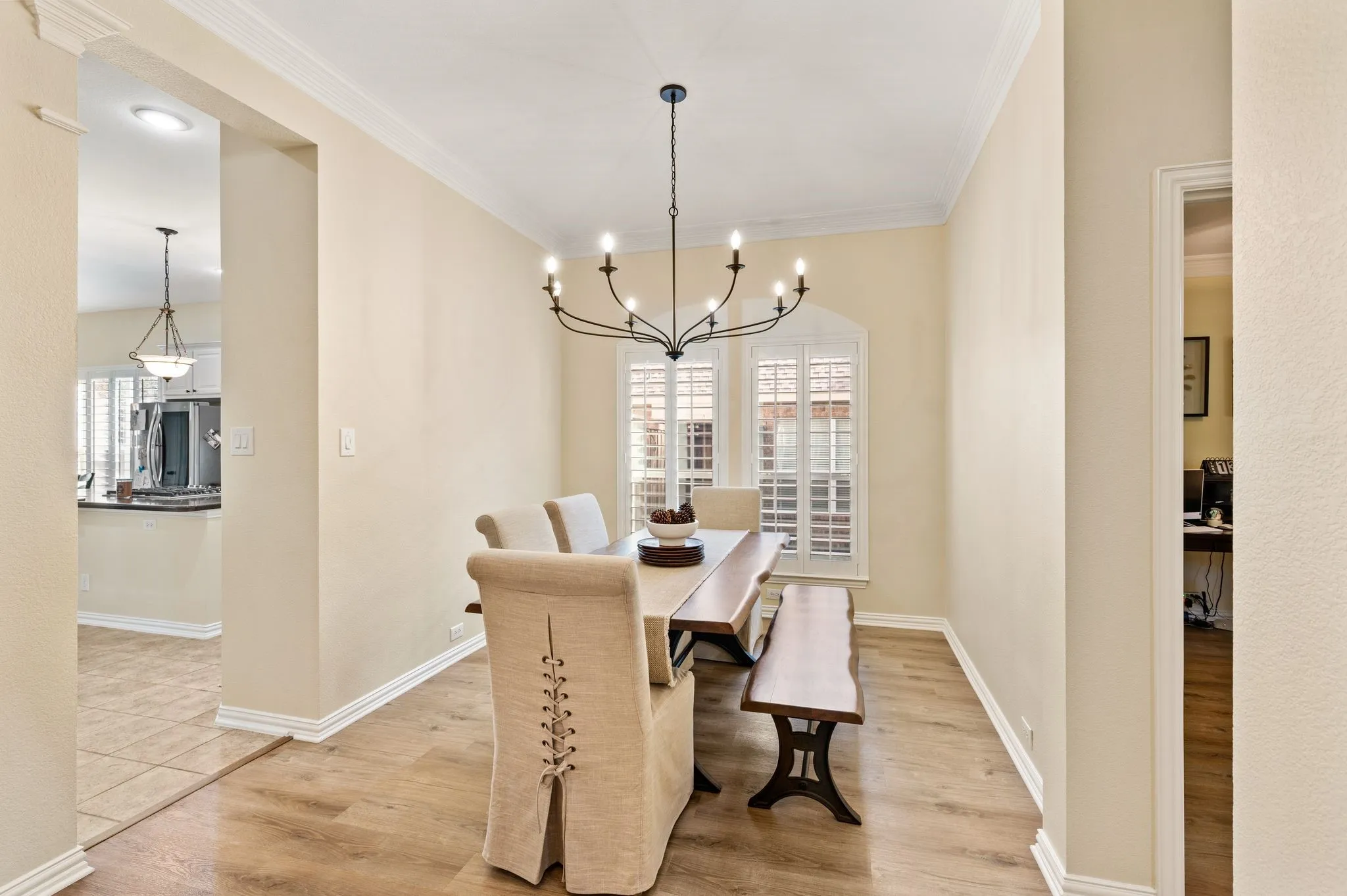 Formal dining wows with recently added designer chandelier, plantation shutters and wood tone floors