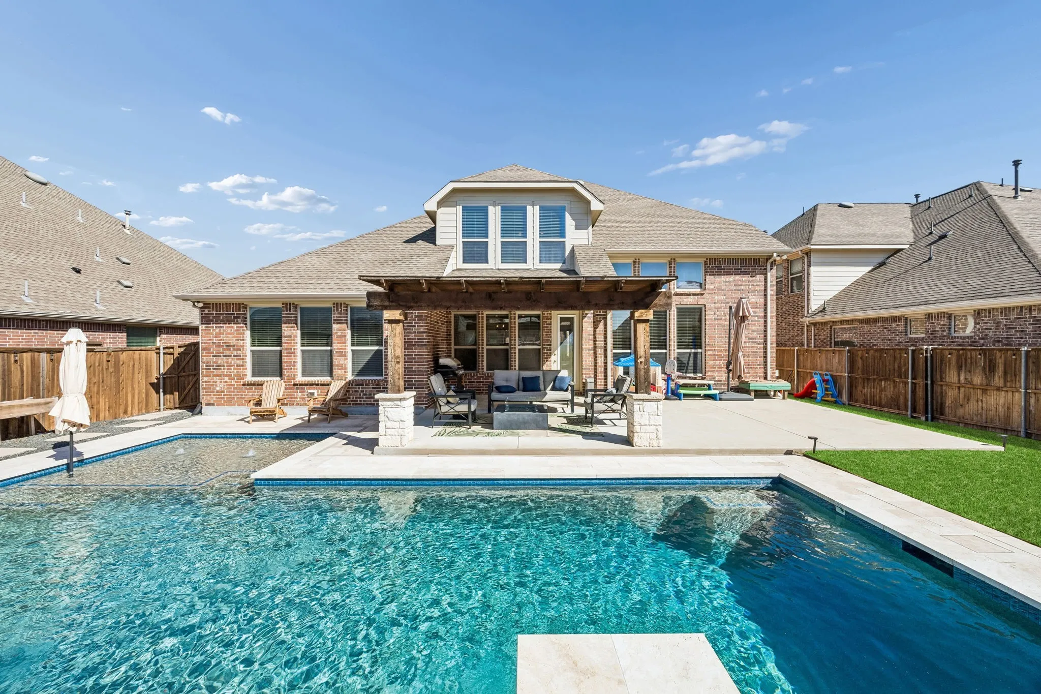 This backyard has it all. Pool with heater, per friendly turf and a 3 hole putting green!
