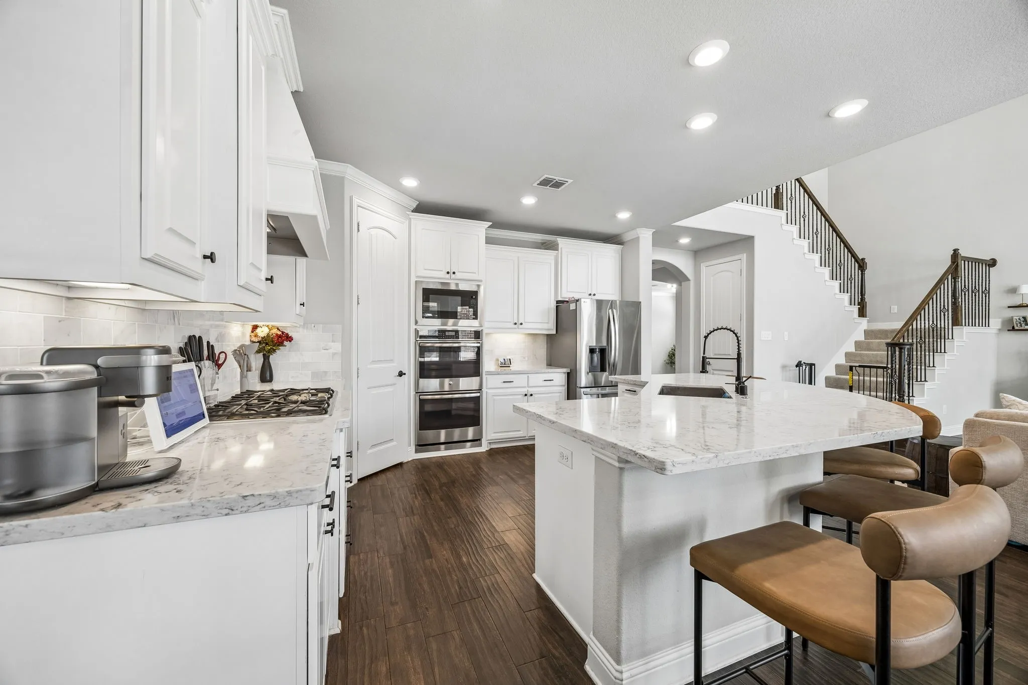 Bright kitchen with stainless appliances and gas cooktop.