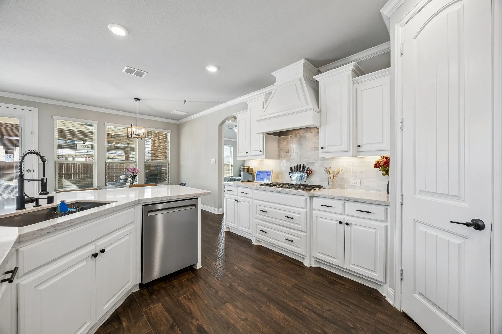 Bright kitchen with stainless appliances and gas cooktop.