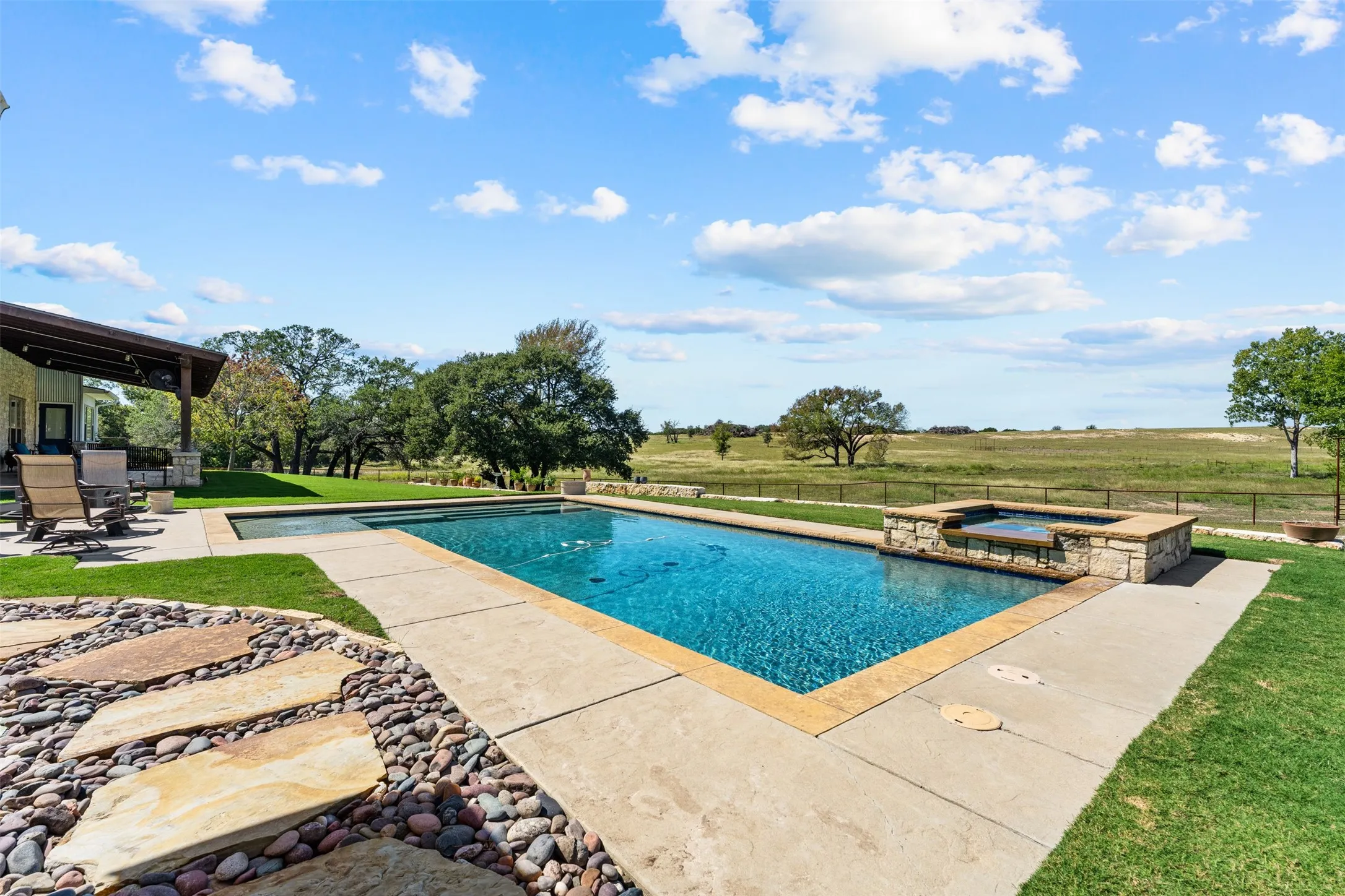 Hilltop views, horses, and lots of privacy in this gorgeous pool area complete with hot tub, bubblers, and a fountain.