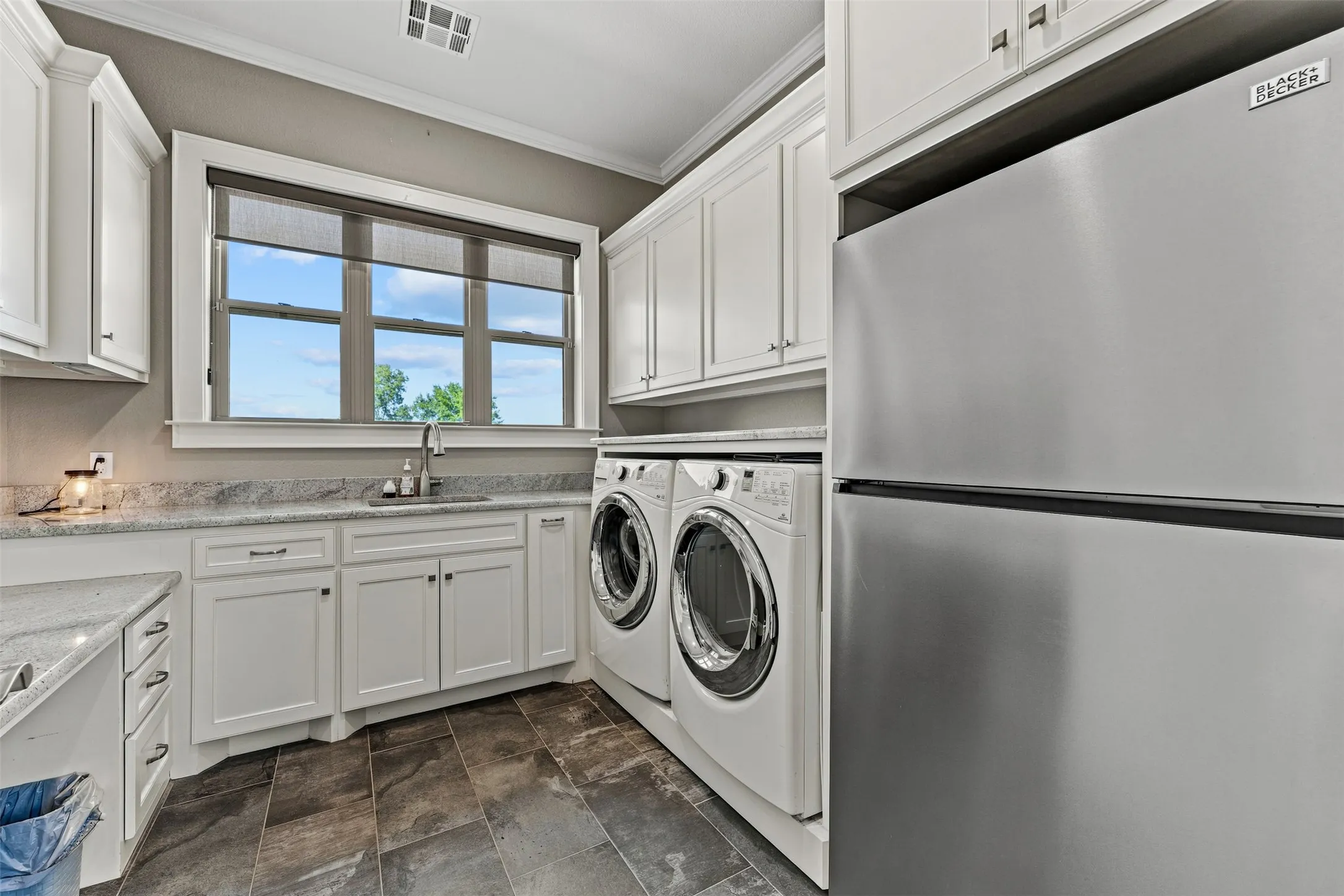 The large laundry room has ample storage and even enough space for a second refrigerator or freezer.