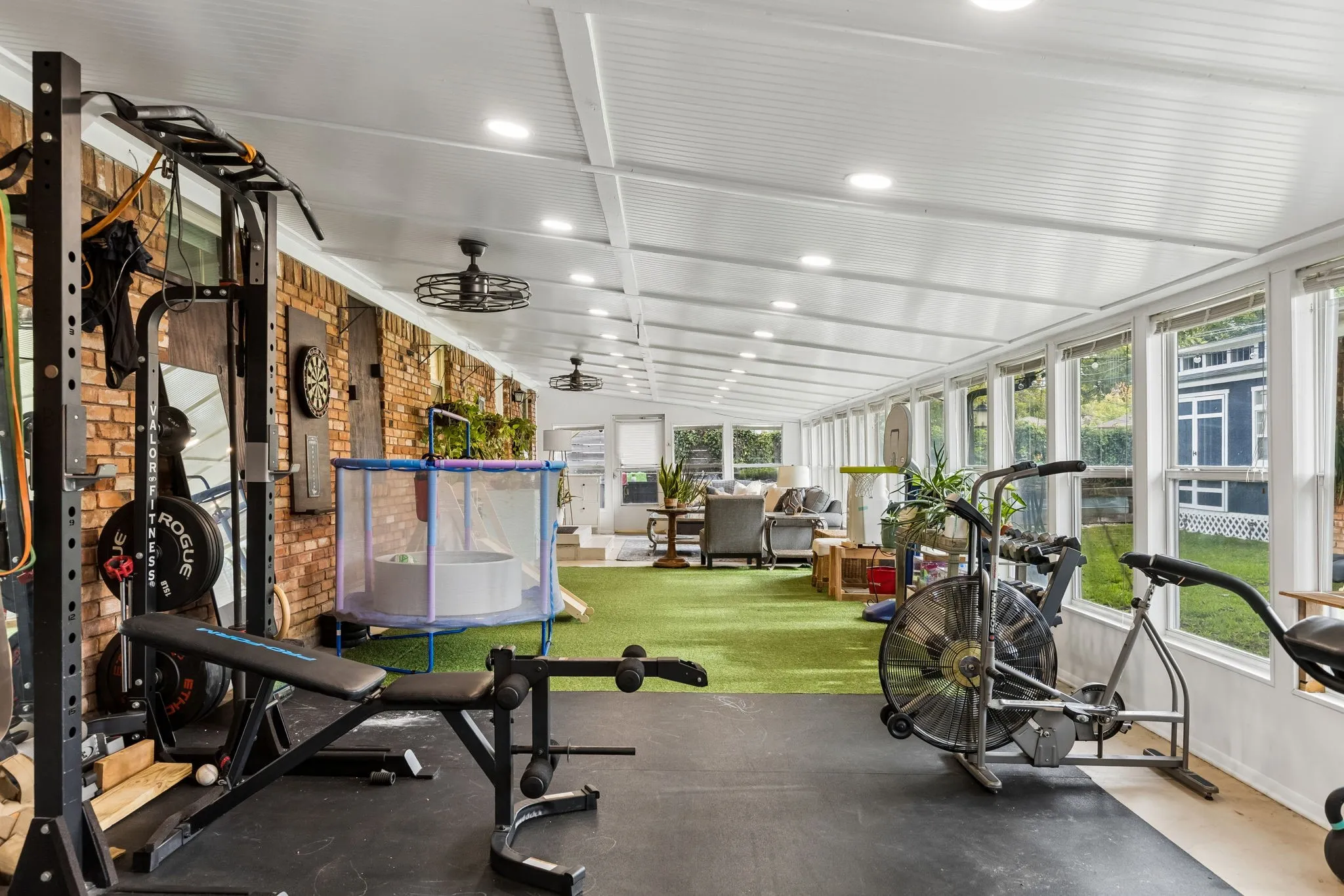 Enclosed patio featuring a brick accent wall, recessed lighting, ceiling fans, and an abundance of windows