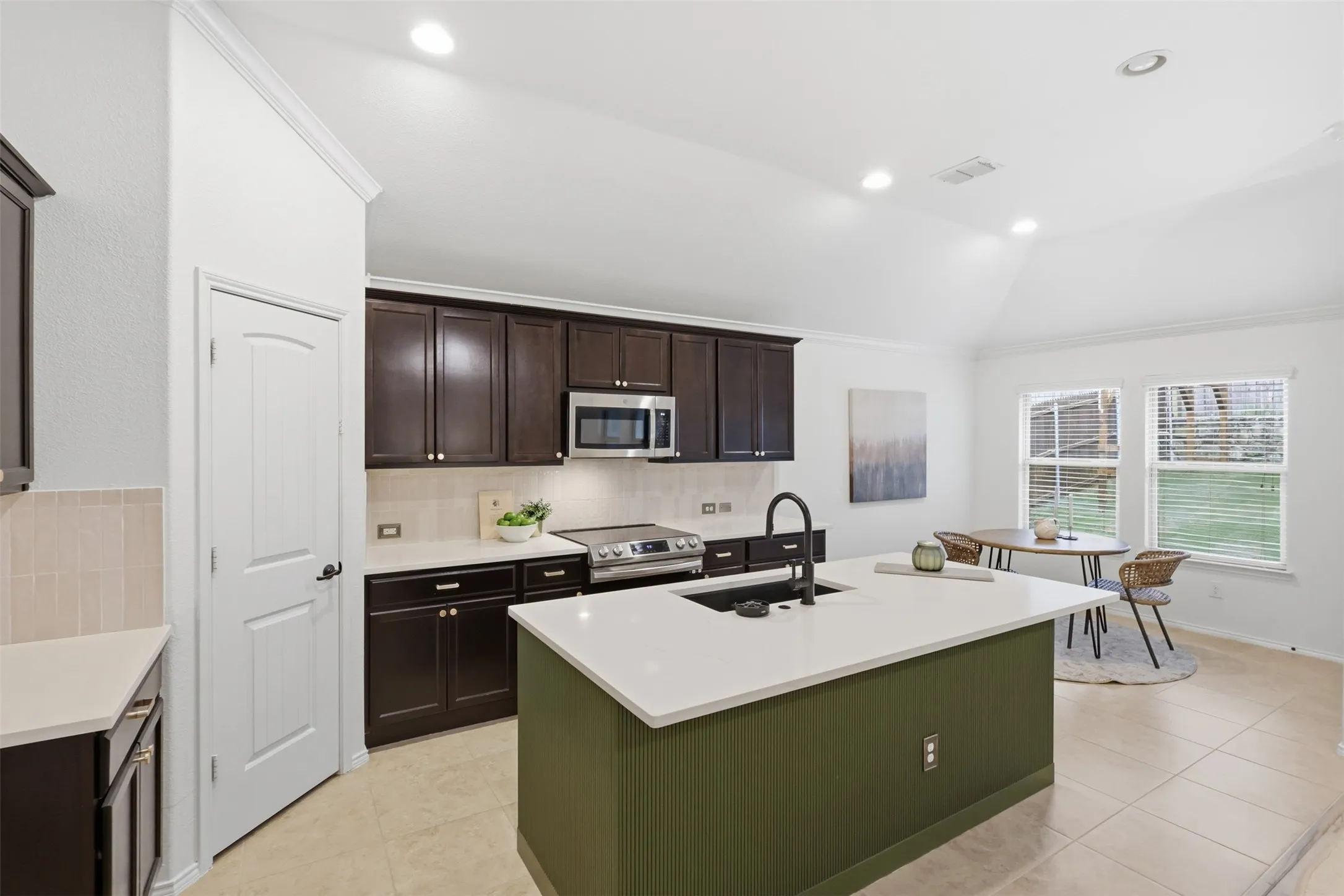 Updated kitchen featuring quartz countertop, large island, deep single basin sink, designer tile and updated faucet
