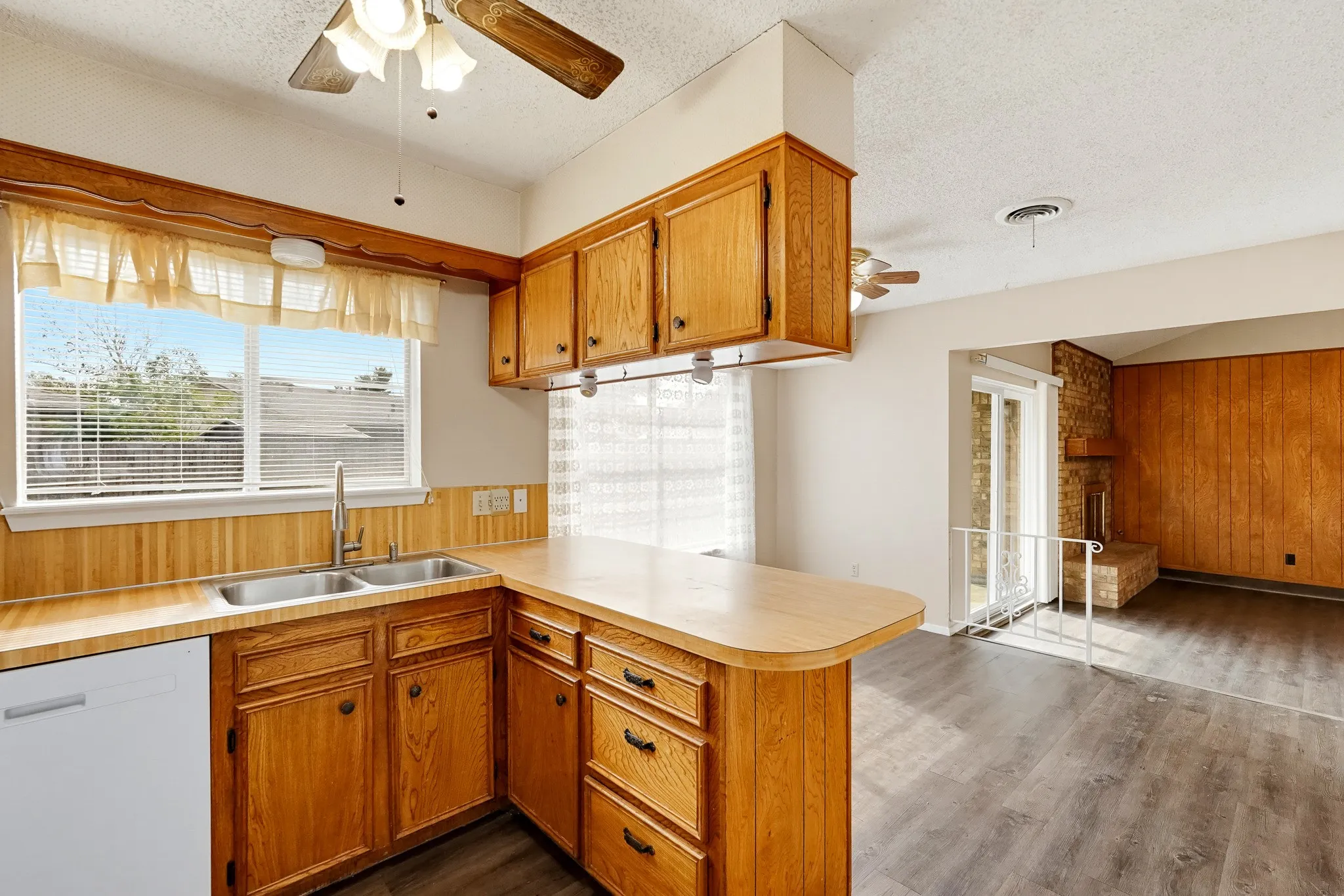 A double basin beneath a bright window takes some of the sting out of cleanup.