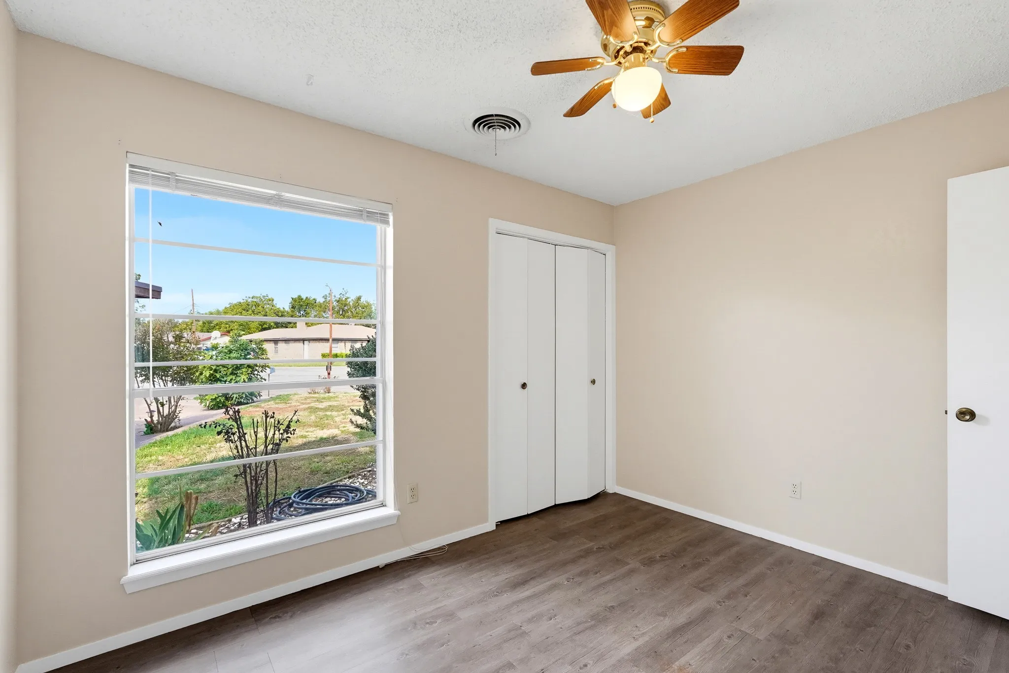 Daylight pours through an oversized pane, with a front-yard view to wake up to.