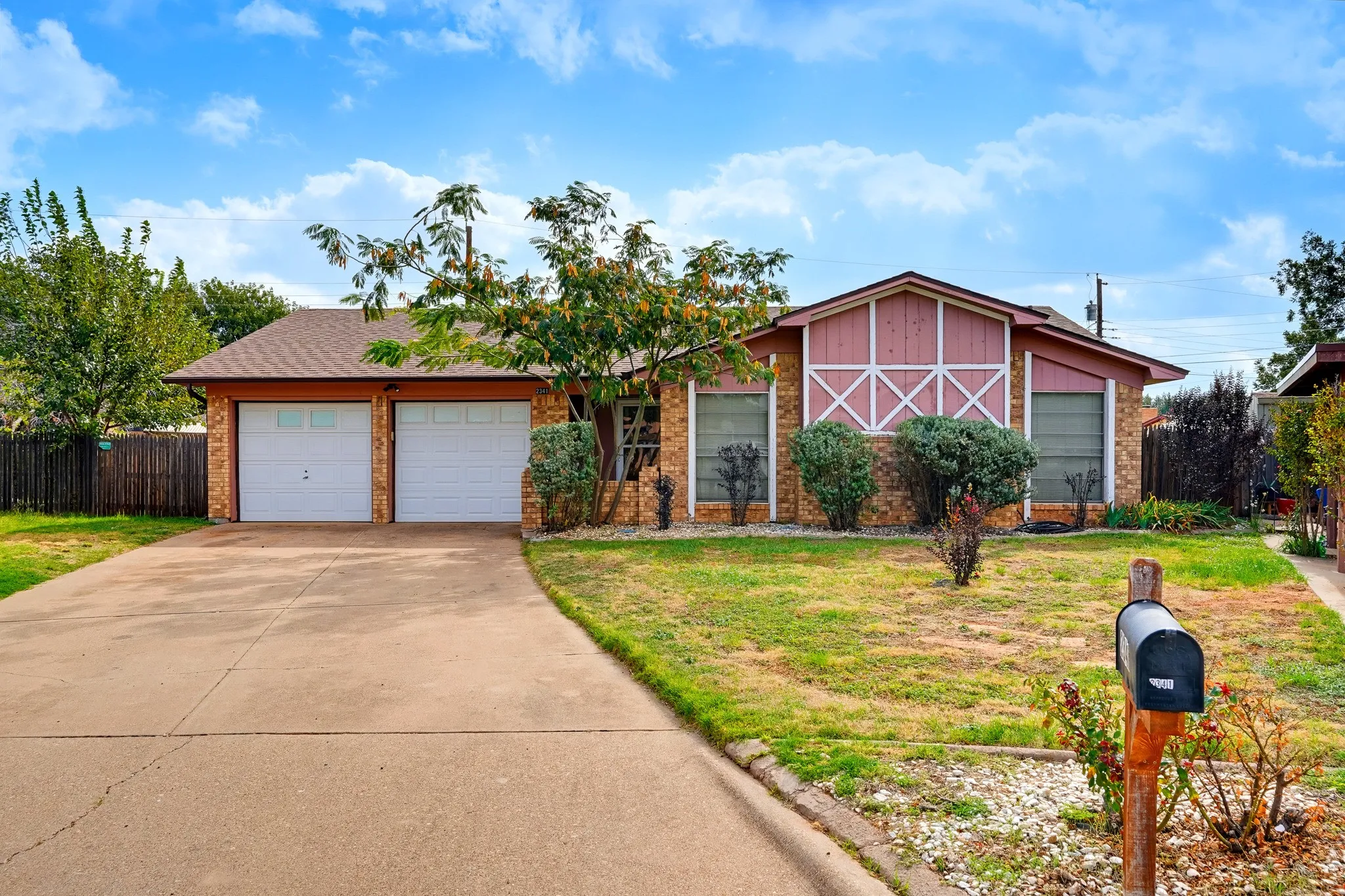 brick ranch with a barn-style gable and a mimosa tree out front, tucked at the end of the cul-de-sac.
