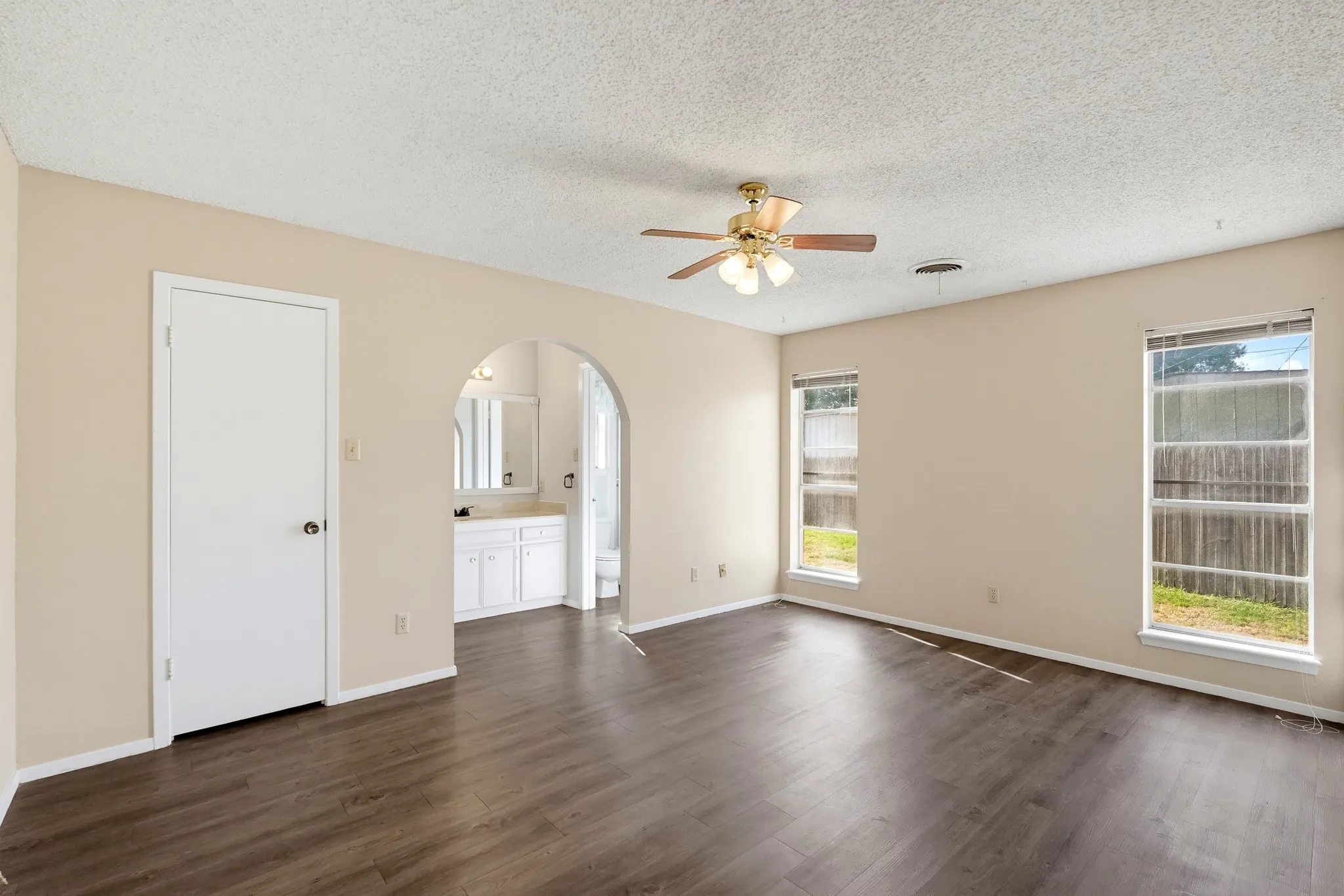 An arched opening leads to a dressing nook, a graceful touch of curved architecture.