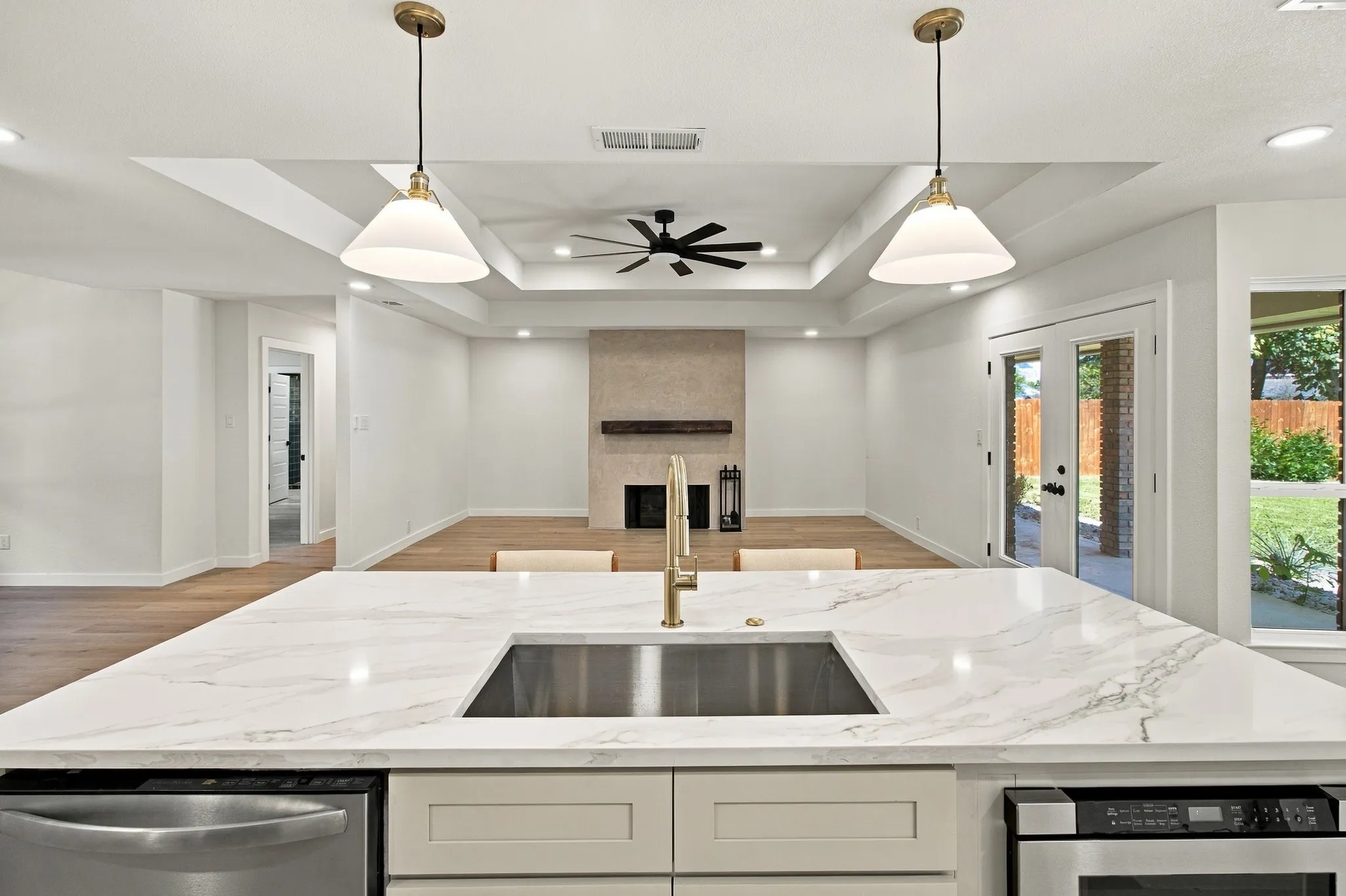 Kitchen featuring a stone-surface island with an undermount stainless steel sink and a metallic finish faucet