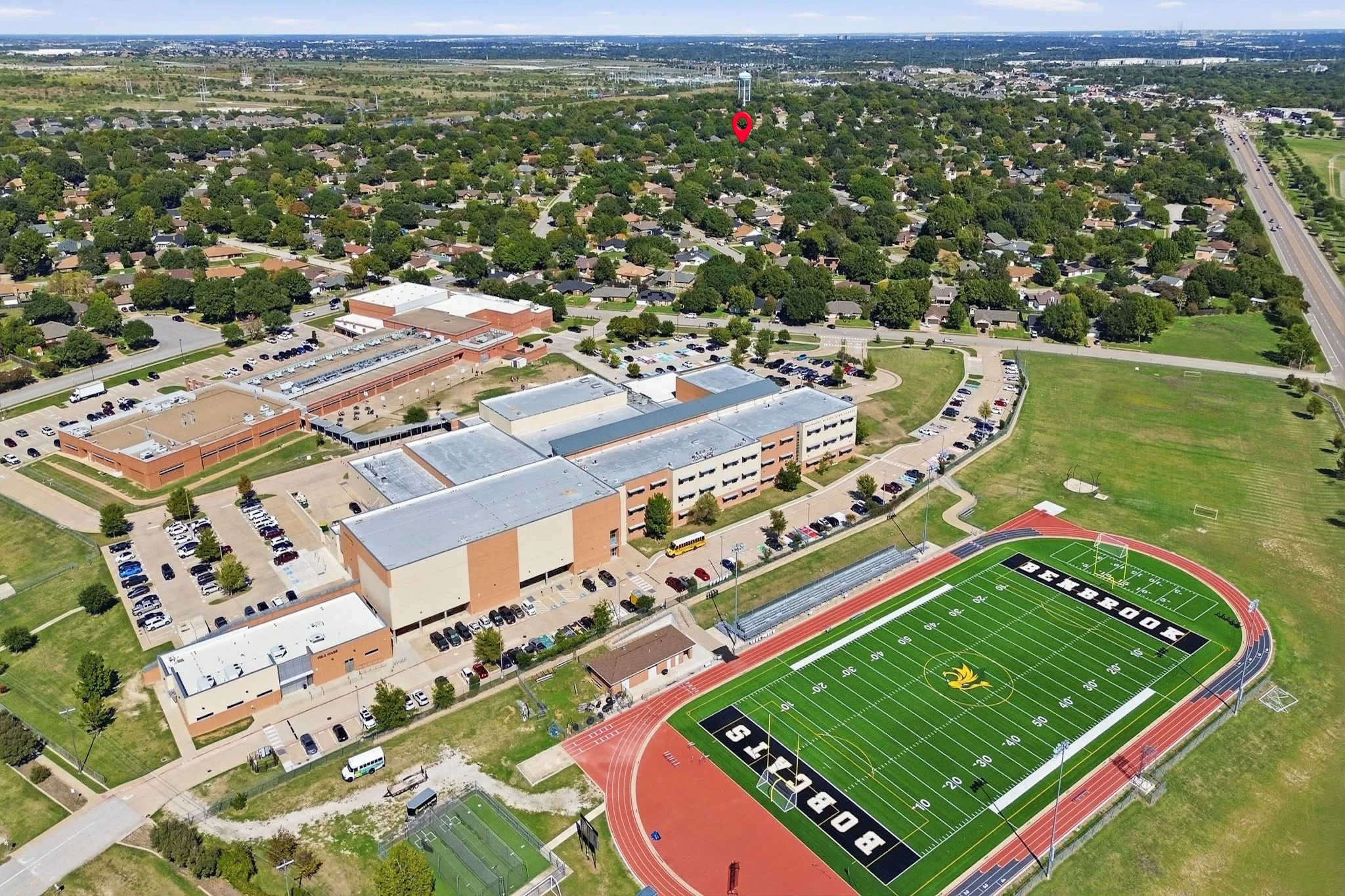 Aerial perspective featuring established residential surroundings, mature tree canopy, and proximity to municipal athletic facilities