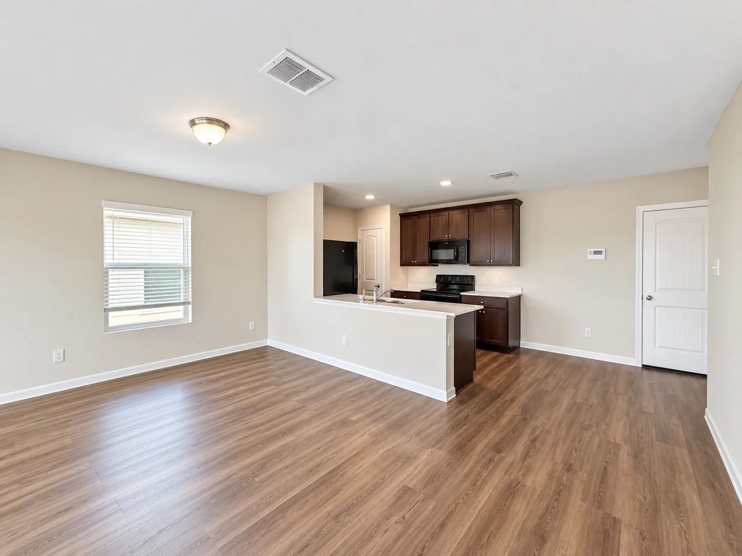 Open-concept living space with wood-finish flooring