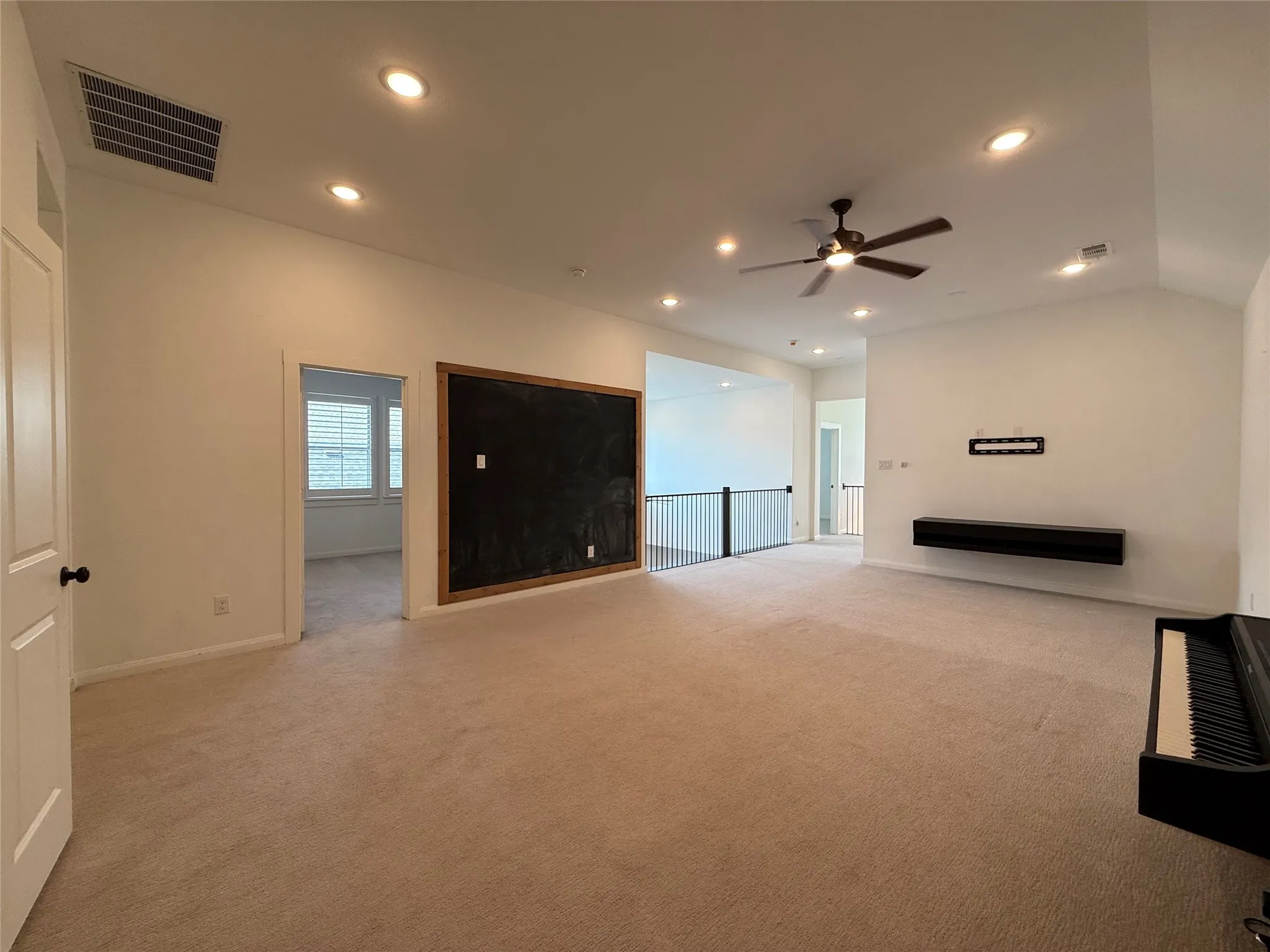 Vaulted ceilings featuring recessed lighting, a ceiling fan, a wall-mounted floating shelf, and a built-in chalkboard