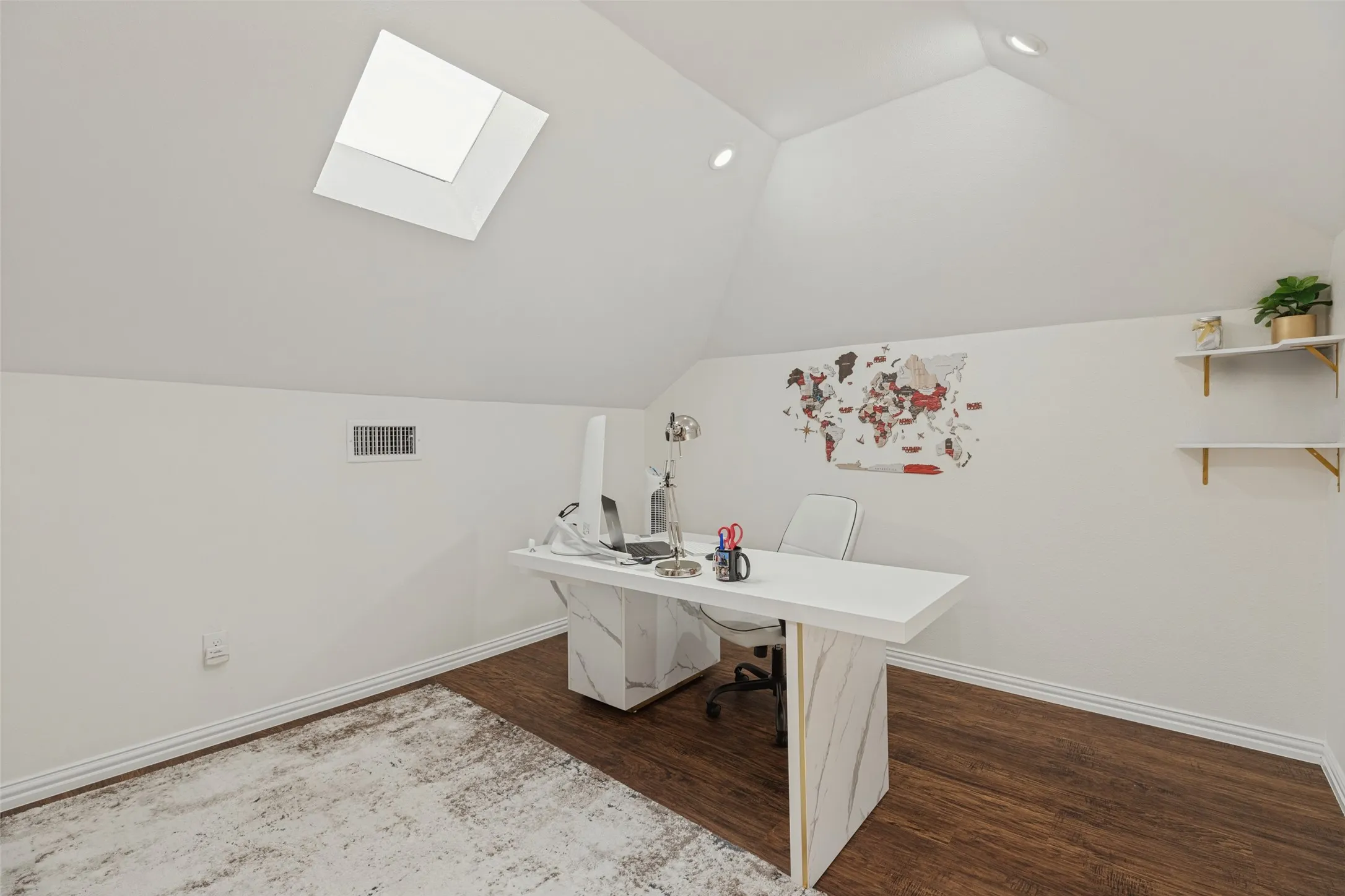 Vaulted ceilings featuring a skylight, recessed lighting, and wall-mounted shelving