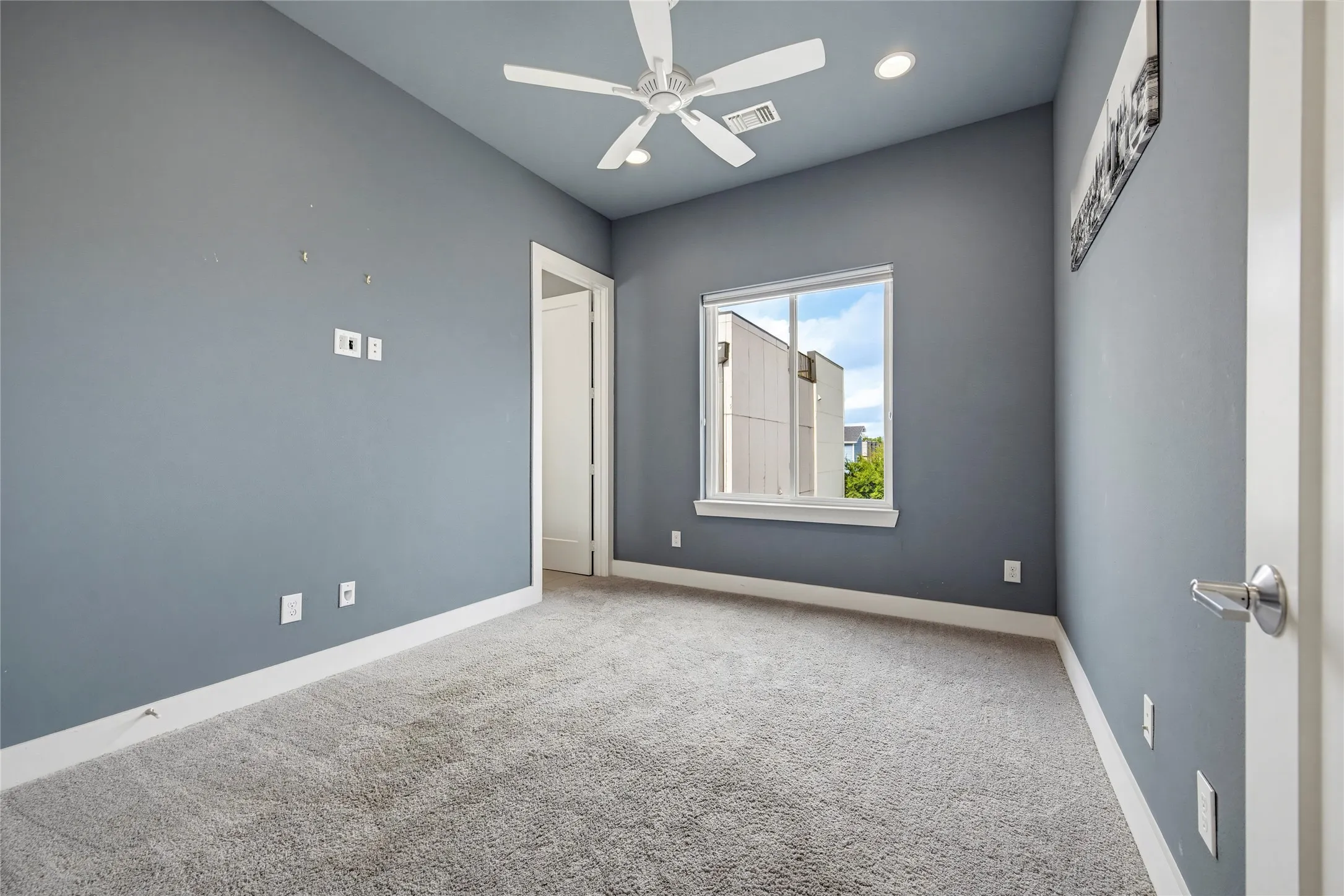 Room featuring high ceilings, neutral carpeting, recessed lighting, and a white ceiling fan with integrated lighting